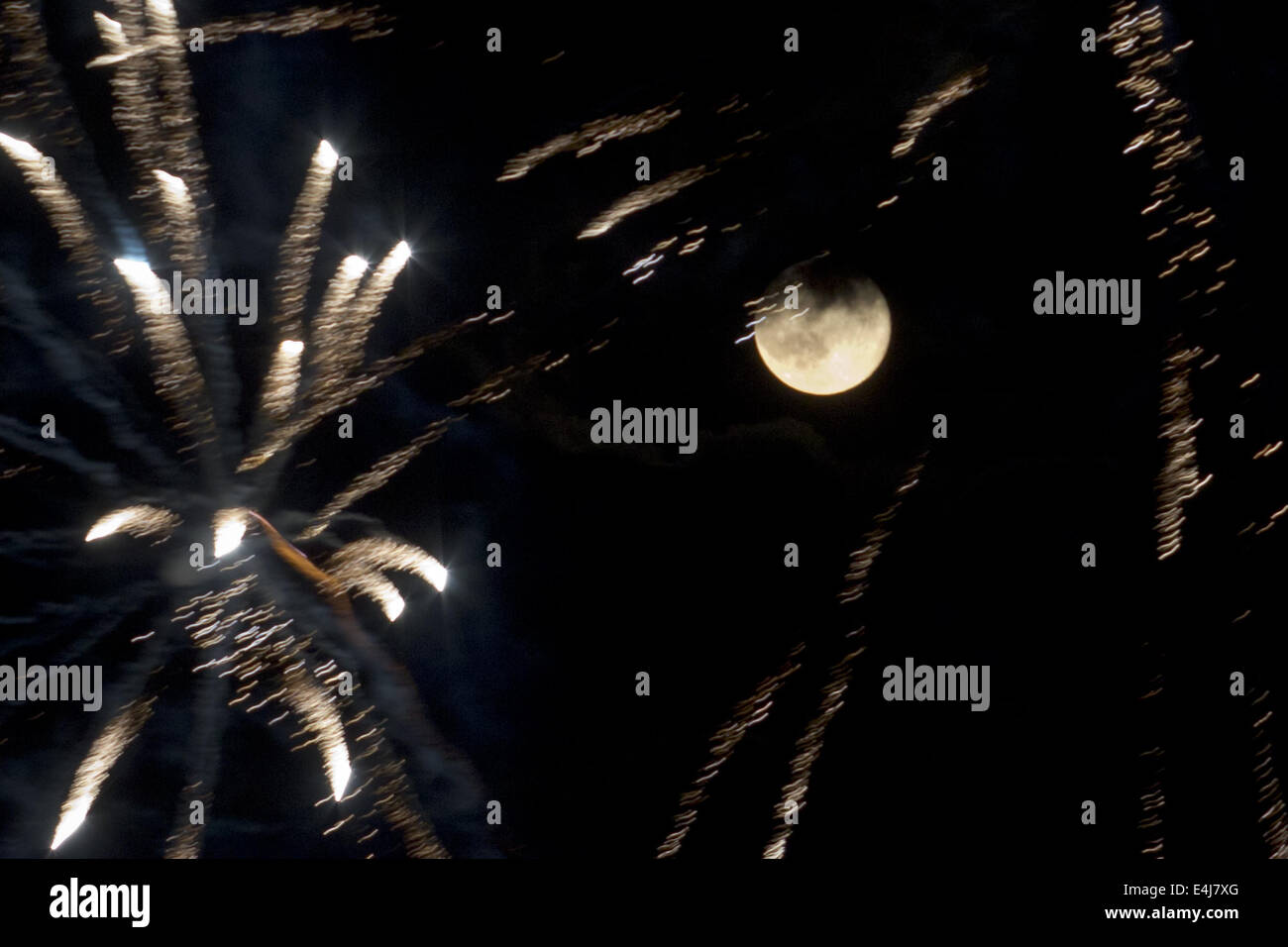 Chester, New York, USA. 12th July, 2014. A perigee full moon, also known as a supermoon, shares the sky with fireworks during a display in Chester, New York. The full moons of August and September will also be supermoons. Credit:  Tom Bushey/ZUMA Wire/Alamy Live News Stock Photo