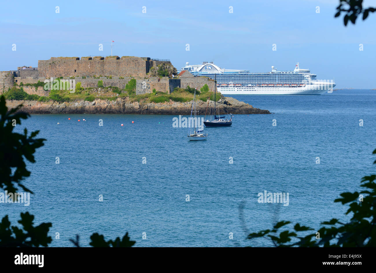 Castle Cornet in Guernsey and the Ruby Princess cruise ship moored just offshore Stock Photo