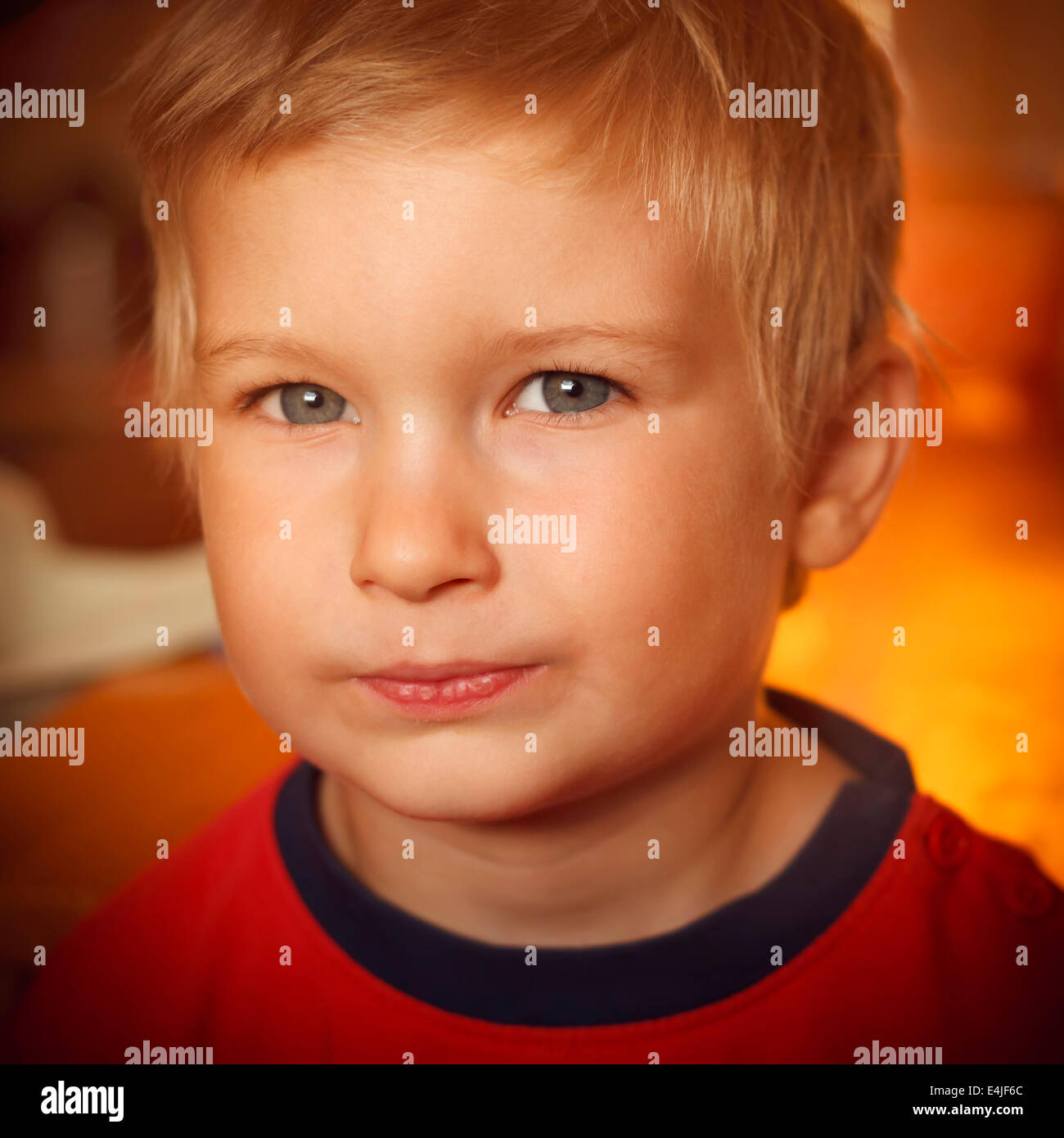 Young boy indoors looking at camera Stock Photo - Alamy