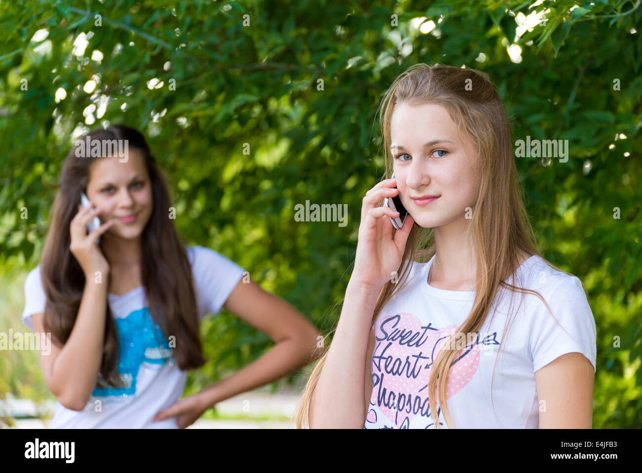 Teen girls talking on cell phone Stock Photo