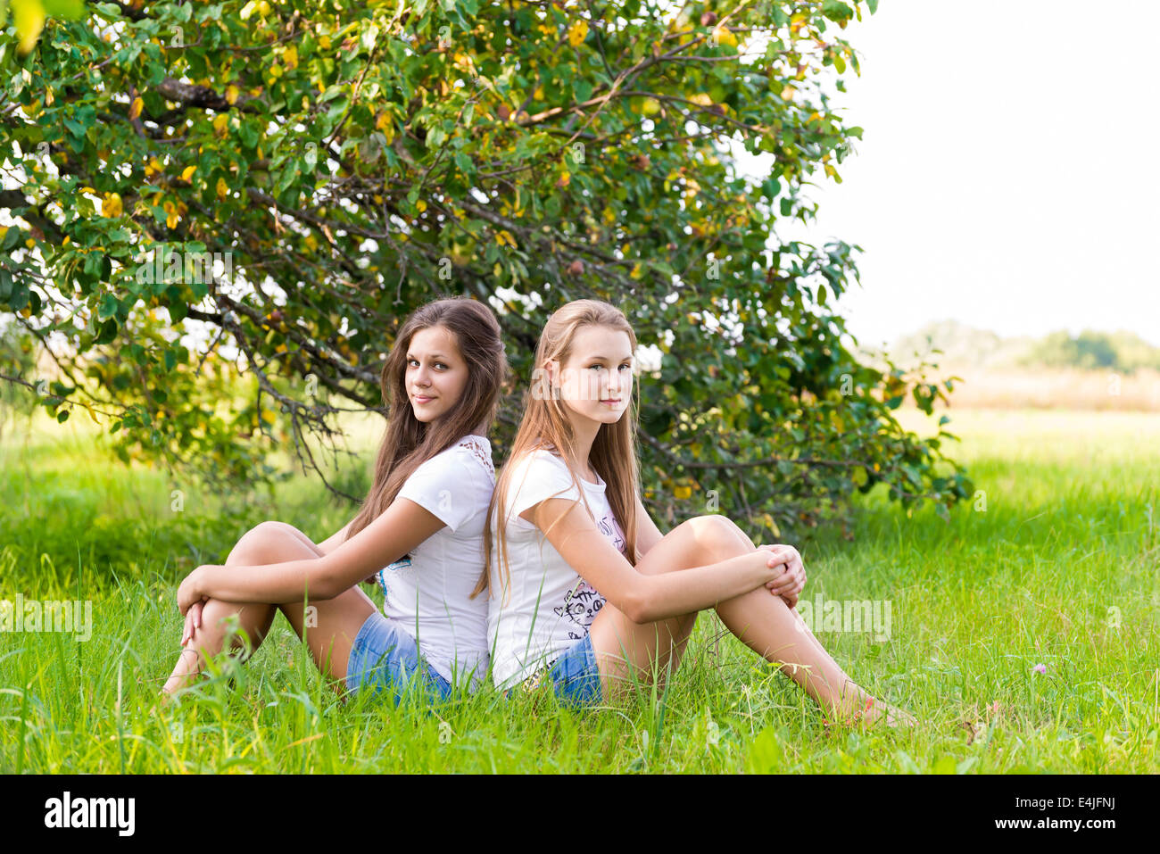 Two girls sitting in the park hi-res stock photography and images - Alamy