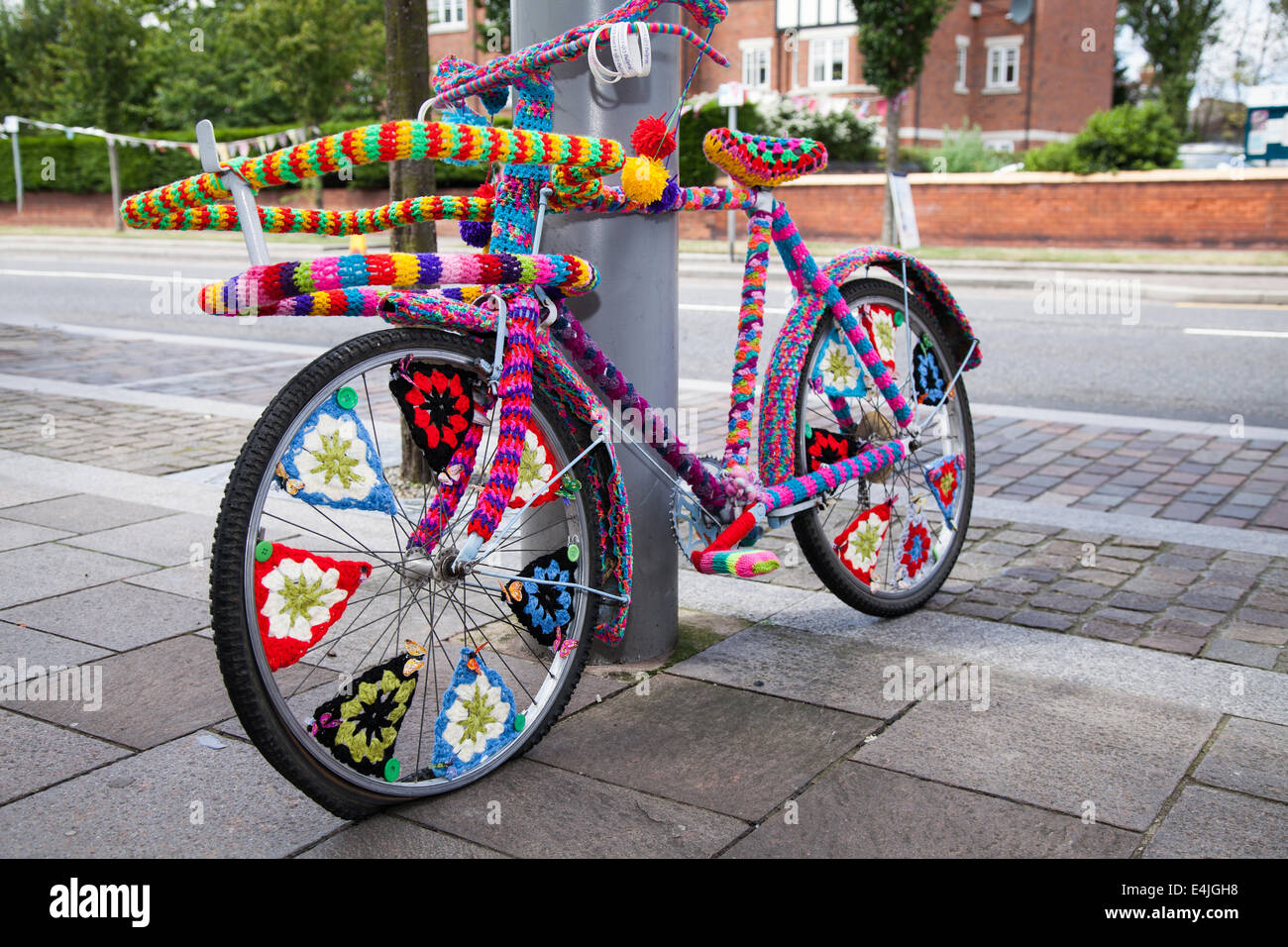 Decorated knitting wool 'Yarn bombed' knitted bike covers, crocheted bicycle, graffiti art knitting, yarnbombing in Hoylake, street arts festival, UK. Stock Photo