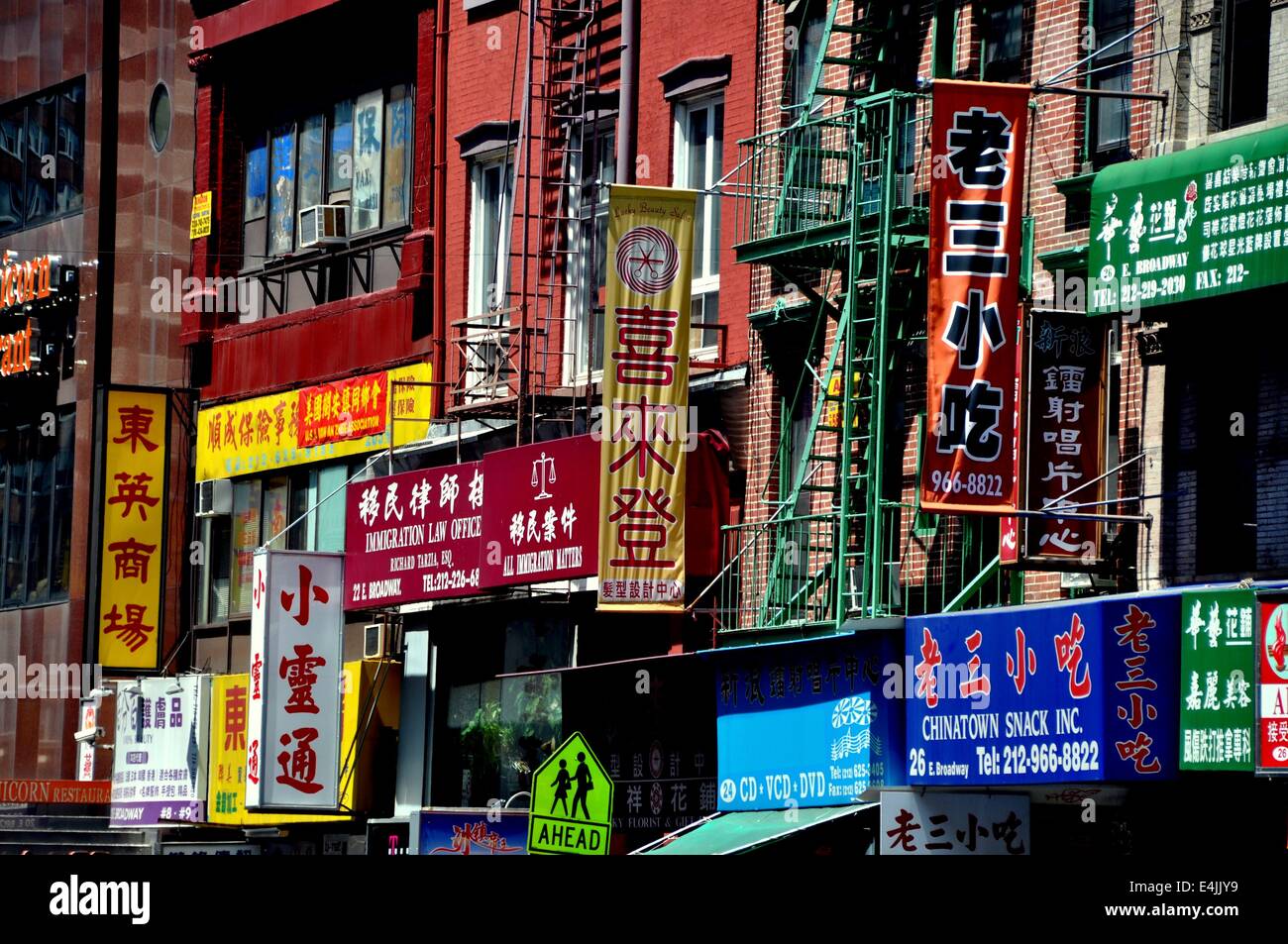 New York, NY:  Shop and business signs, mostly written in Chinese characters, hang from tenenment buildings on East Broadway Stock Photo