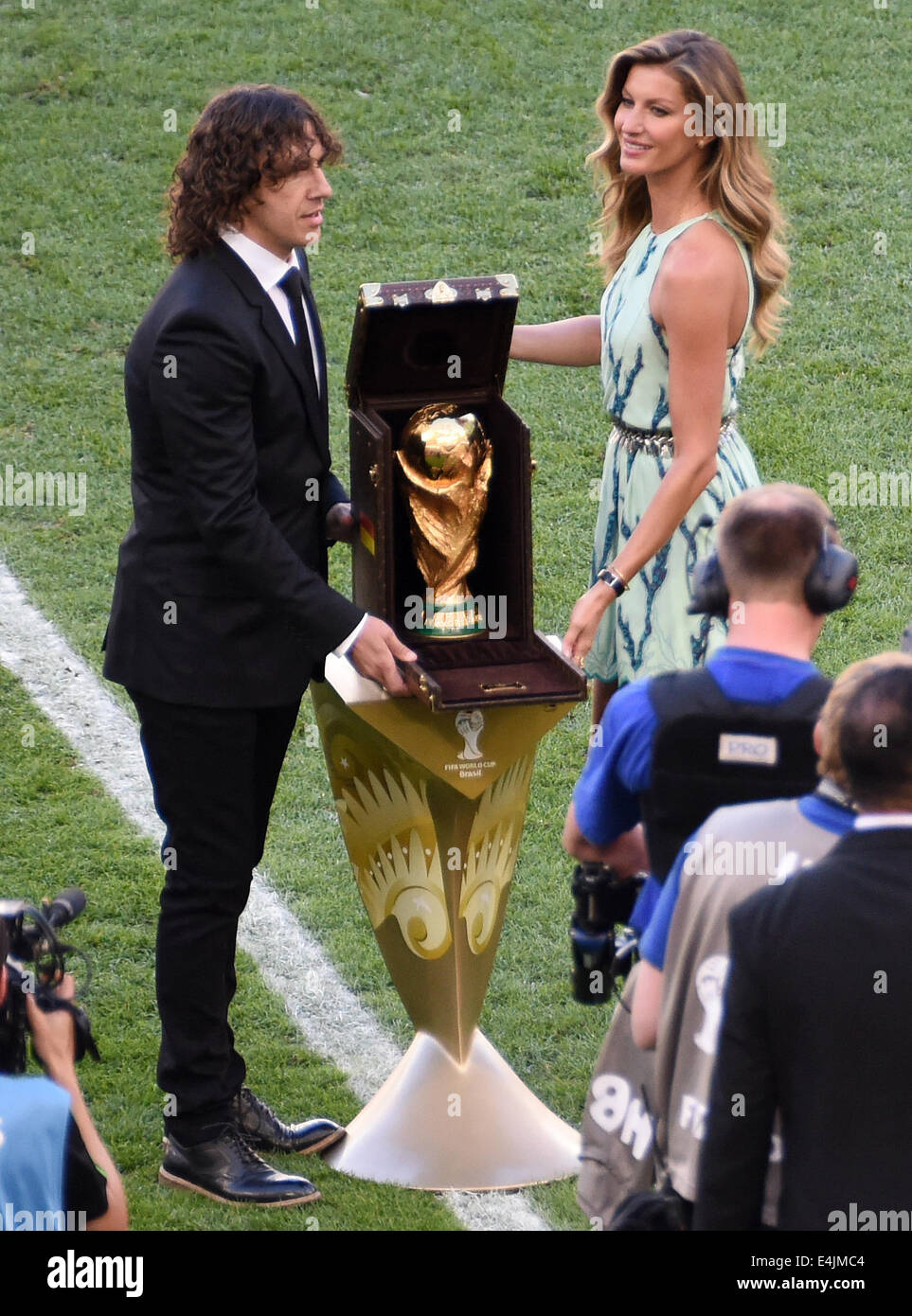 Rio de Janeiro, Brazil. 13th July, 2014. Former soccer Carles Puyol of Spain and Brazilian fashion model Gisele Buendchen pose with World Cup trophy prior to the FIFA World Cup 2014 final soccer match between Germany and Argentina at the Estadio do Maracana in Rio de Janeiro, Brazil, 13 July 2014. Photo: Thomas Eisenhuth/dpa/Alamy Live News Stock Photo