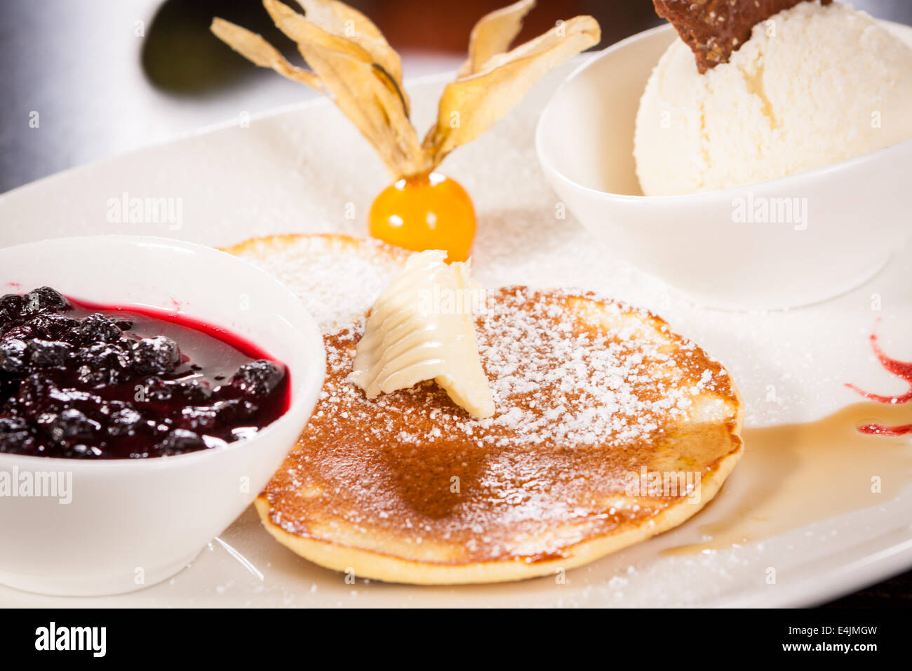 tasty sweet pancakes with vanilla icecream fruit jam and syrup topping