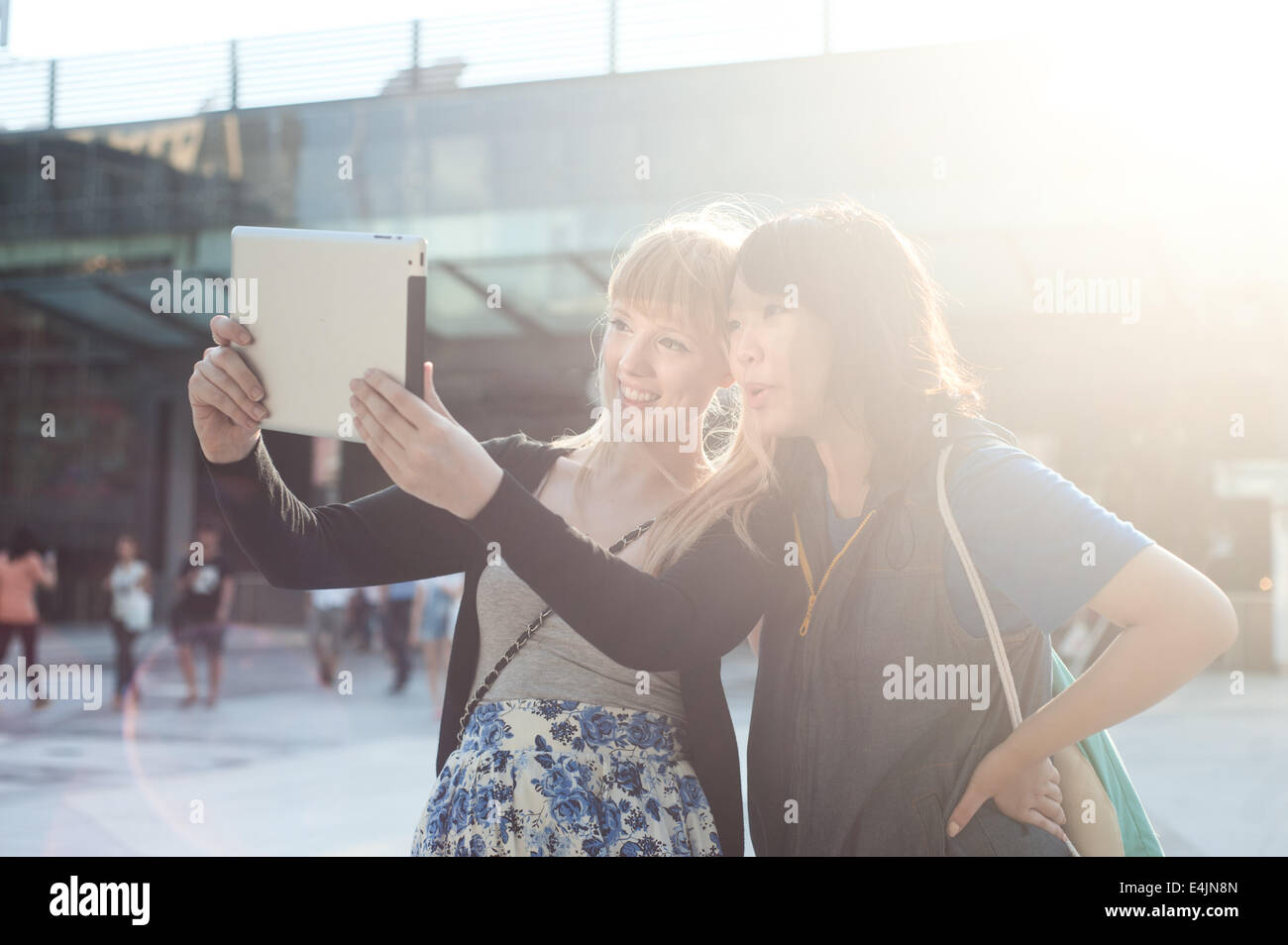 Two young women using digital tablet to take a self photo Stock Photo ...