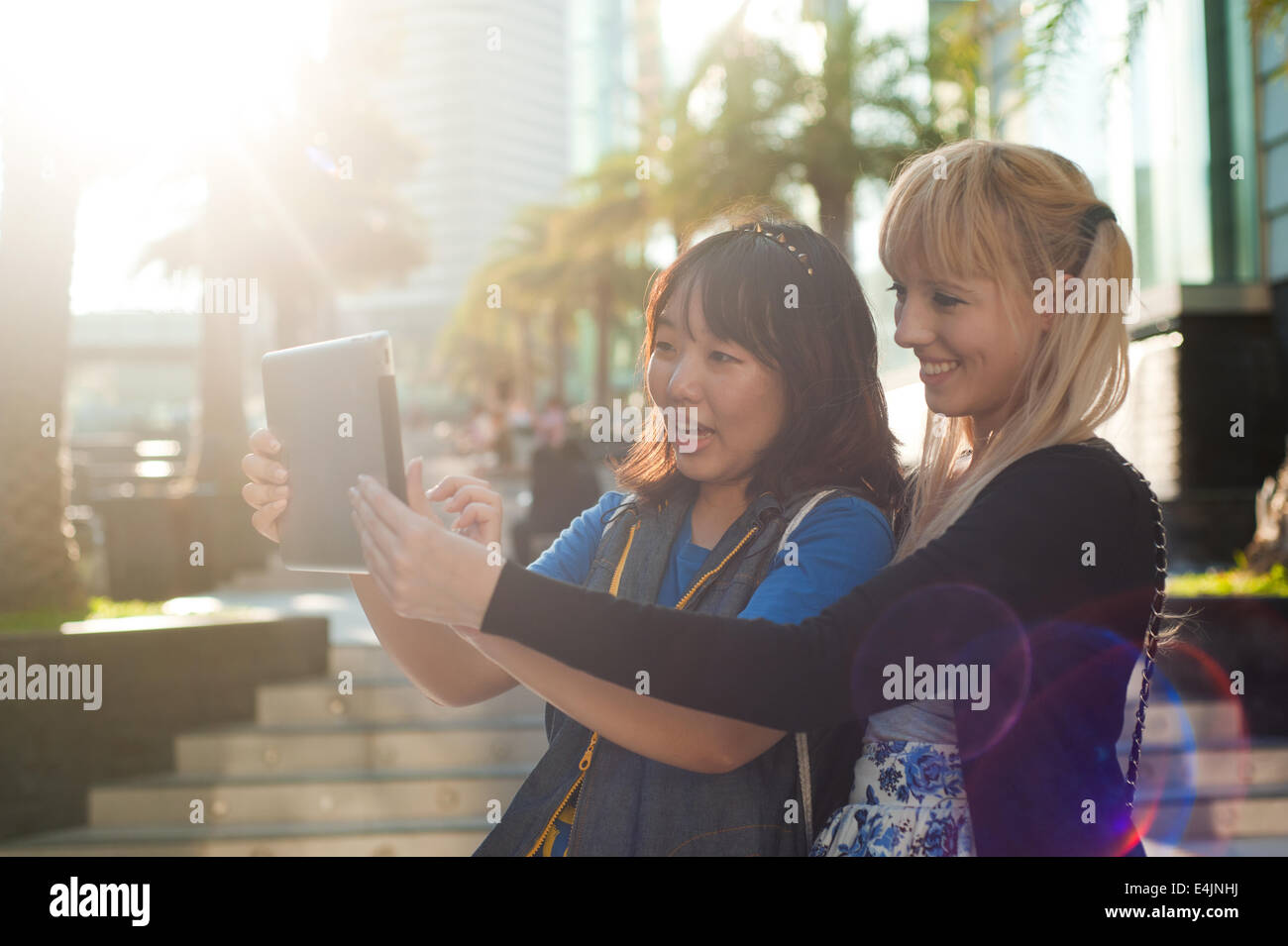 Two young women using digital tablet Stock Photo - Alamy