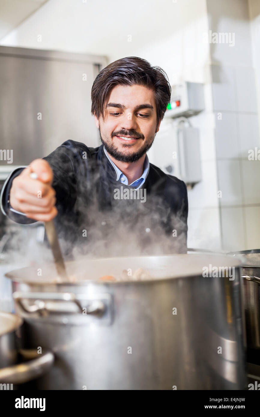 Professional chef in a commercial kitchen cooking a vegetable stir fry