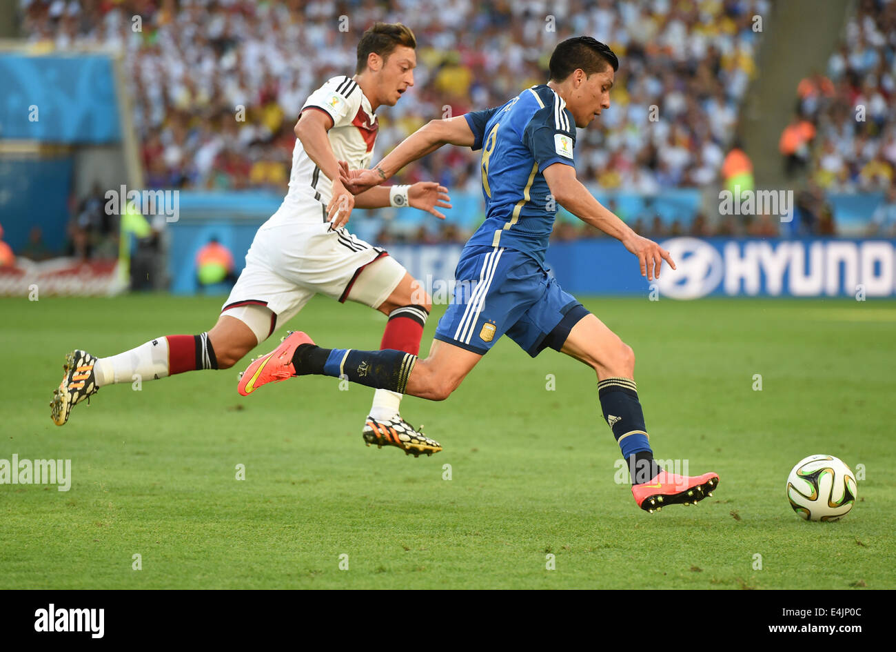 Rio de Janeiro, Brazil. 13th July, 2014. Mesut Oezil of Germany and Enzo Perez of Argenina vie for the ball during the FIFA World Cup 2014 final soccer match between Germany and Argentina at the Estadio do Maracana in Rio de Janeiro, Brazil, 13 July 2014. Photo: Marcus Brandt/dpa/Alamy Live News Stock Photo
