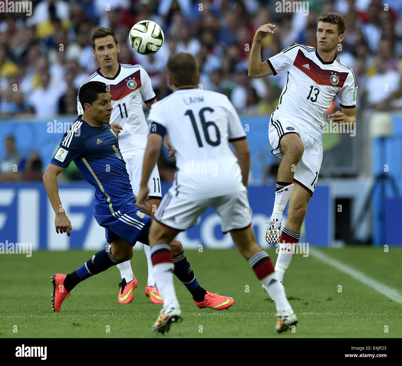 Rio De Janeiro, Brazil. 13th July, 2014. Germany's Thomas Mulle (R) vies with Argentina's Enzo Perez (L) during the final match between Germany and Argentina of 2014 FIFA World Cup at the Estadio do Maracana Stadium in Rio de Janeiro, Brazil, on July 13, 2014. Credit:  Li Ga/Xinhua/Alamy Live News Stock Photo