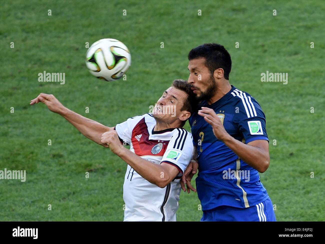 Rio De Janeiro, Brazil. 13th July, 2014. Germany's Miroslav Klose competes for a header with Argentina's Ezequiel Garay during the final match between Germany and Argentina of 2014 FIFA World Cup at the Estadio do Maracana Stadium in Rio de Janeiro, Brazil, on July 13, 2014. Credit:  Li Ga/Xinhua/Alamy Live News Stock Photo