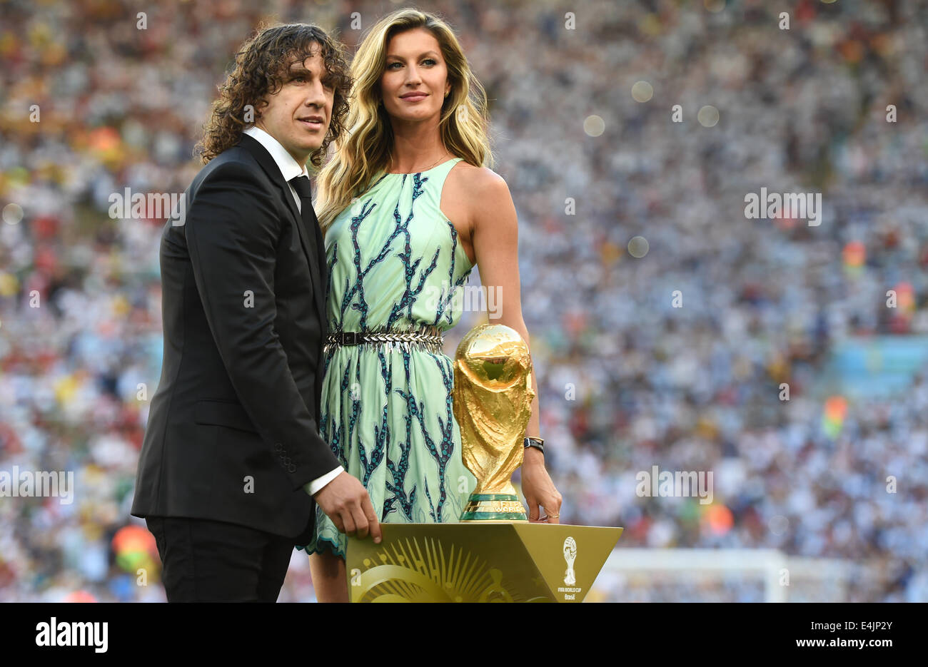 Rio de Janeiro, Brazil. 13th July, 2014. Former soccer Carles Puyol of Spain and Brazilian fashion model Gisele Buendchen pose with World Cup trophy prior to the FIFA World Cup 2014 final soccer match between Germany and Argentina at the Estadio do Maracana in Rio de Janeiro, Brazil, 13 July 2014. Photo: Andreas Gebert/dpa/Alamy Live News Stock Photo