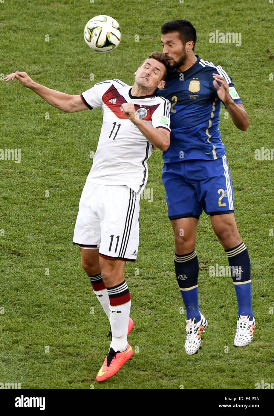 Rio De Janeiro, Brazil. 13th July, 2014. Germany's Miroslav Klose competes a header with Argentina's Ezequiel Garay during the final match between Germany and Argentina of 2014 FIFA World Cup at the Estadio do Maracana Stadium in Rio de Janeiro, Brazil, on July 13, 2014. Credit:  Lui Siu Wai/Xinhua/Alamy Live News Stock Photo