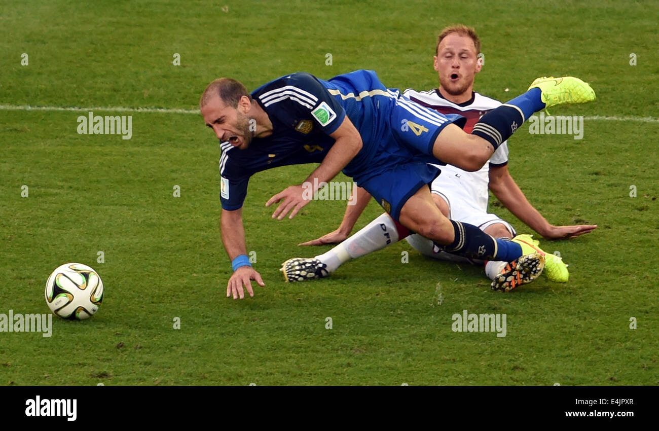 Rio De Janeiro, Brazil. 13th July, 2014. Germany's Benedikt Howedes and Argentina's Pablo Zabaleta fall down during the final match between Germany and Argentina of 2014 FIFA World Cup at the Estadio do Maracana Stadium in Rio de Janeiro, Brazil, on July 13, 2014. Credit:  Li Ga/Xinhua/Alamy Live News Stock Photo
