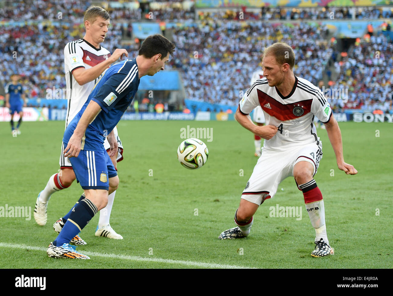 Rio de Janeiro, Brazil. 13th July, 2014. Benedikt Hoewedes (R) and Toni Kroos (L) of Germany and Lionel Messi of Argentina vie for the ball during the FIFA World Cup 2014 final soccer match between Germany and Argentina at the Estadio do Maracana in Rio de Janeiro, Brazil, 13 July 2014. Photo: Marcus Brandt/dpa/Alamy Live News Stock Photo