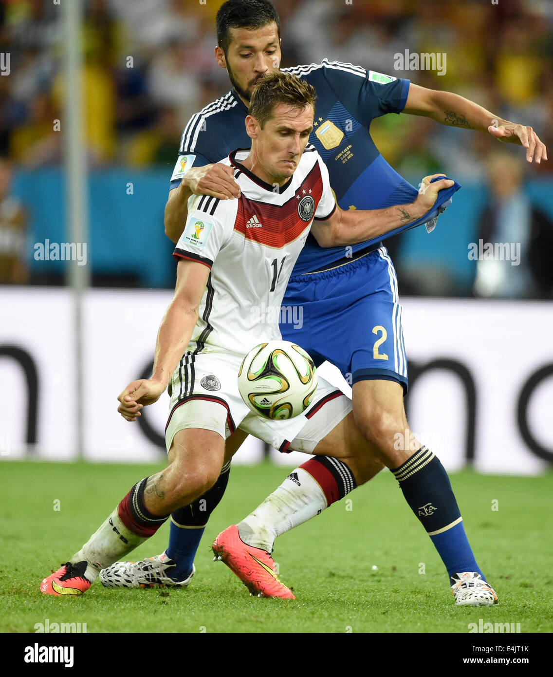Rio de Janeiro, Brazil. 13th July, 2014. Miroslav Klose (front) of Germany and Ezequiel Garay of Argentina vie for the ball during the FIFA World Cup 2014 final soccer match between Germany and Argentina at the Estadio do Maracana in Rio de Janeiro, Brazil, 13 July 2014. Photo: Marcus Brandt/dpa/Alamy Live News Stock Photo
