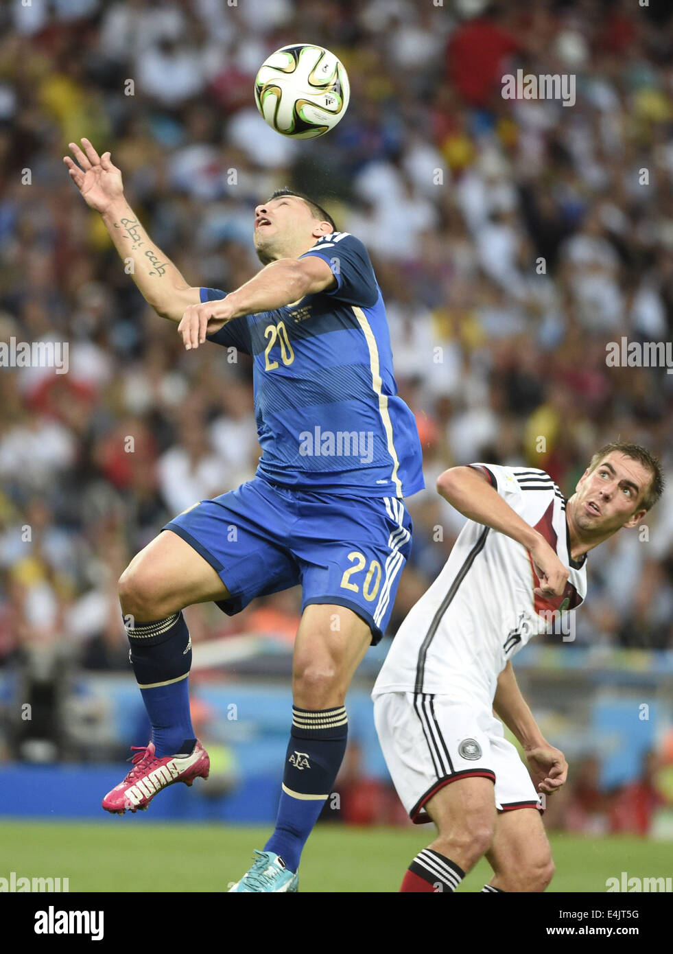 Rio De Janeiro, Brazil. 13th July, 2014. Argentina's Sergio Aguero (L) heads the ball against Germany's Philipp Lahm during the final match between Germany and Argentina of 2014 FIFA World Cup at the Estadio do Maracana Stadium in Rio de Janeiro, Brazil, on July 13, 2014. Credit:  Yang Lei/Xinhua/Alamy Live News Stock Photo