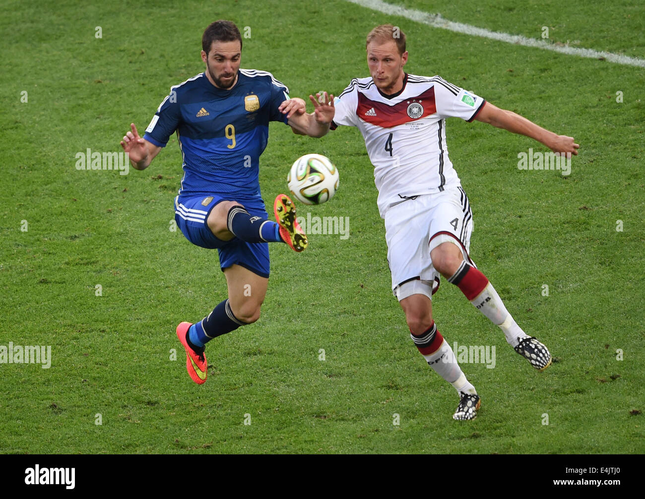 Rio De Janeiro, Brazil. 13th July, 2014. Germany's Benedikt Howedes vies with Argentina's Gonzalo Higuain during the final match between Germany and Argentina of 2014 FIFA World Cup at the Estadio do Maracana Stadium in Rio de Janeiro, Brazil, on July 13, 2014. Credit:  Li Ga/Xinhua/Alamy Live News Stock Photo