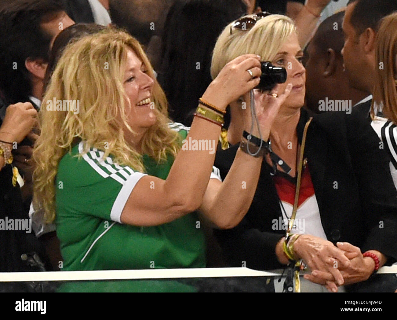 Rio de Janeiro, Brazil. 13th July, 2014. Daniela Loew (L), wife of head coach Joachim Loew of Germany, takes photos in the stands during the FIFA World Cup 2014 final soccer match between Germany and Argentina at the Estadio do Maracana in Rio de Janeiro, Brazil, 13 July 2014. Photo: Marcus Brandt/dpa/Alamy Live News Stock Photo