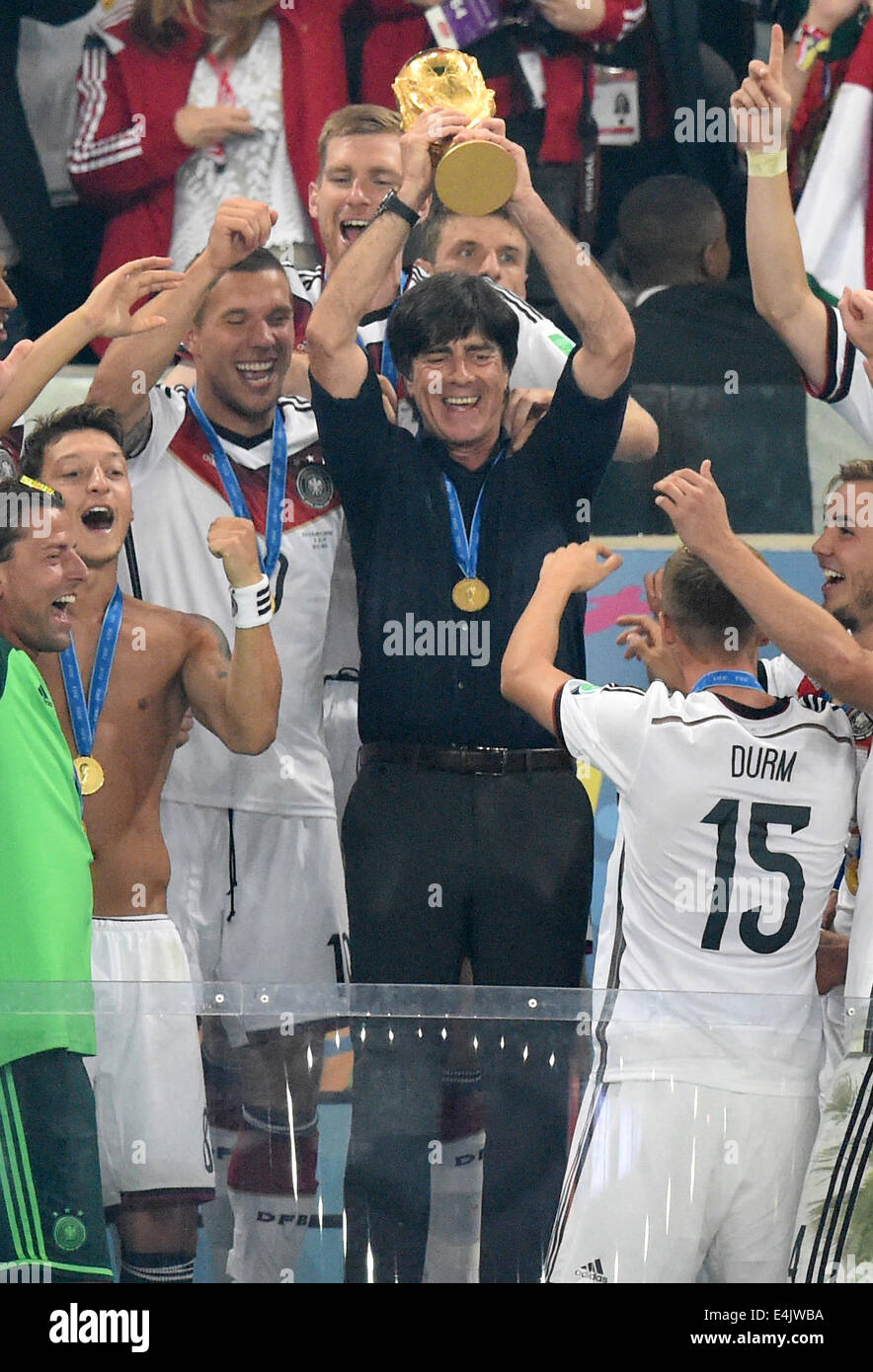 Rio de Janeiro, Brazil. 13th July, 2014. Head coach Joachim Loew (C) of Germany lifts up the World Cup trophy between his team after winning the FIFA World Cup 2014 final soccer match between Germany and Argentina at the Estadio do Maracana in Rio de Janeiro, Brazil, 13 July 2014. Photo: Marcus Brandt/dpa/Alamy Live News Stock Photo