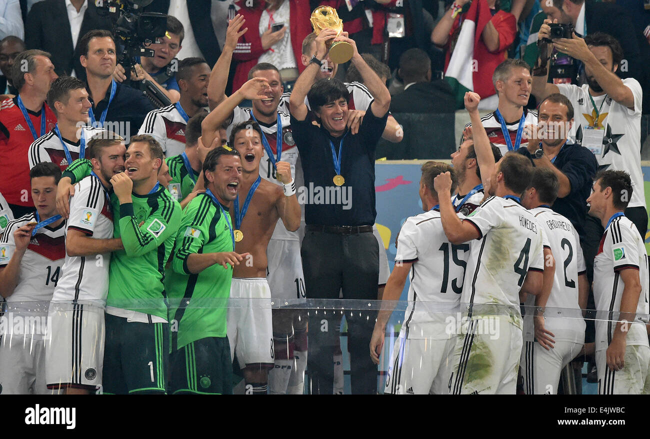 Rio de Janeiro, Brazil. 13th July, 2014. Head coach Joachim Loew (C) of Germany lifts up the World Cup trophy between his team after winning the FIFA World Cup 2014 final soccer match between Germany and Argentina at the Estadio do Maracana in Rio de Janeiro, Brazil, 13 July 2014. Photo: Marcus Brandt/dpa/Alamy Live News Stock Photo