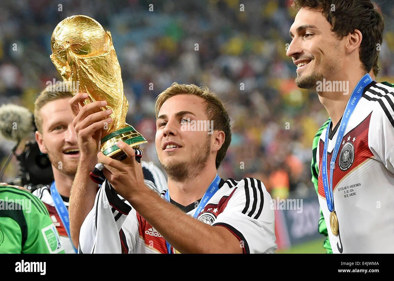 Rio de Janeiro, Brazil. 13th July, 2014. Mario Goetze of Germany who shot the winning goal poses with the World Cup after winning the FIFA World Cup 2014 final soccer match between Germany and Argentina at the Estadio do Maracana in Rio de Janeiro, Brazil, 13 July 2014. At right his team-mate Mats Hummels. Photo: Marcus Brandt/dpa/Alamy Live News Stock Photo