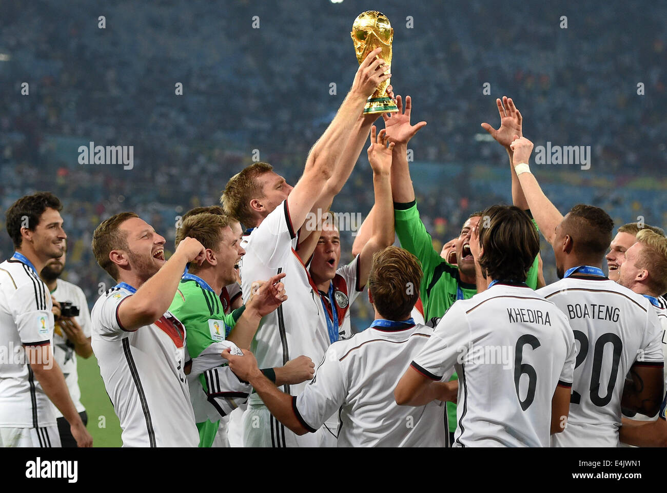 Rio de Janeiro, Brazil. 13th July, 2014. Per Mertesacker (C) of Germany lifts up the World Cup trophy between his teammates after winning the FIFA World Cup 2014 final soccer match between Germany and Argentina at the Estadio do Maracana in Rio de Janeiro, Brazil, 13 July 2014. Photo: Marcus Brandt/dpa/Alamy Live News Stock Photo