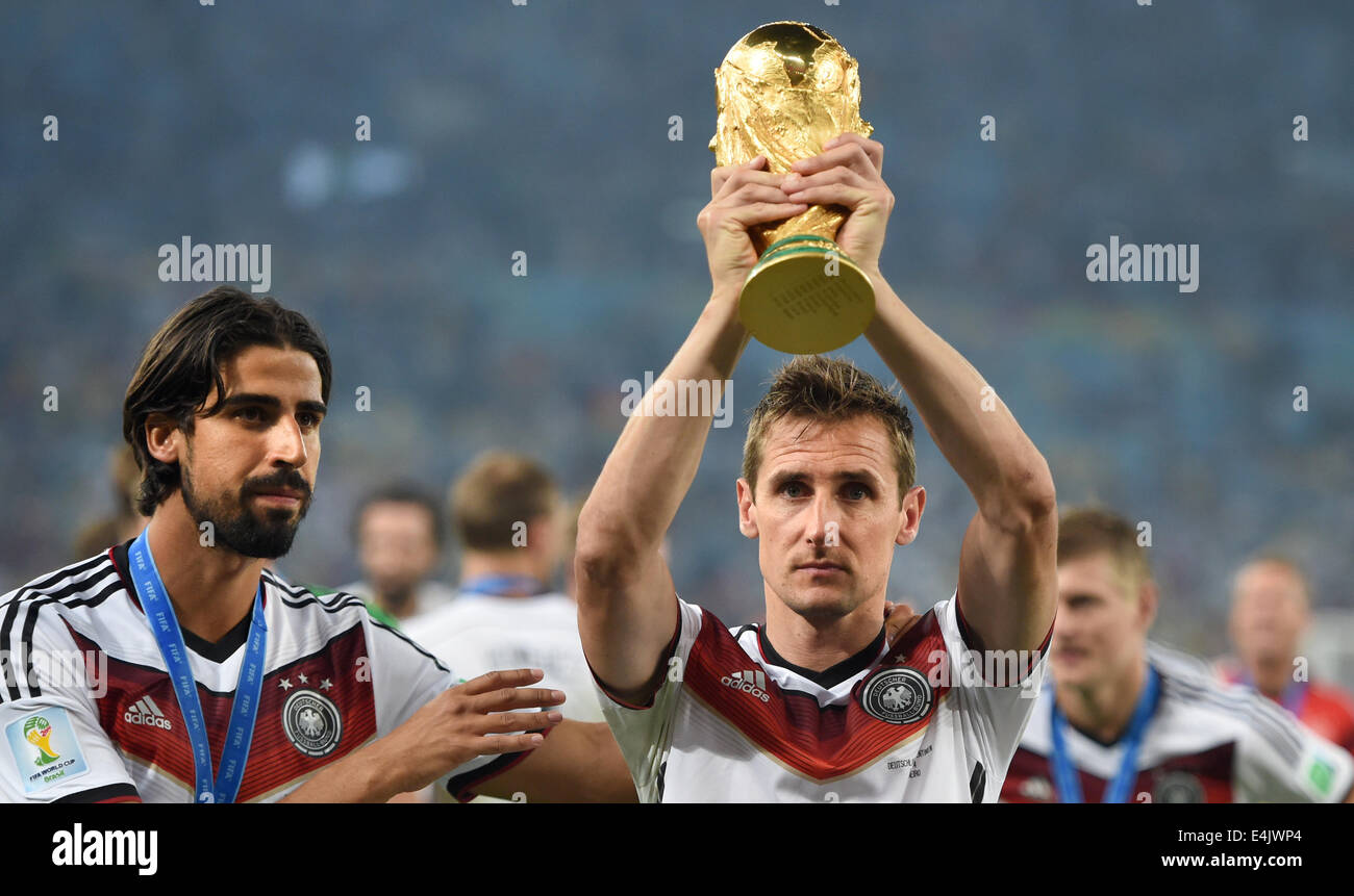 Rio de Janeiro, Brazil. 13th July, 2014. Miroslav Klose (R) of Germany poses with the World Cup trophy next to Sami Khedira (L) after winning the FIFA World Cup 2014 final soccer match between Germany and Argentina at the Estadio do Maracana in Rio de Janeiro, Brazil, 13 July 2014. Photo: Marcus Brandt/dpa/Alamy Live News Stock Photo