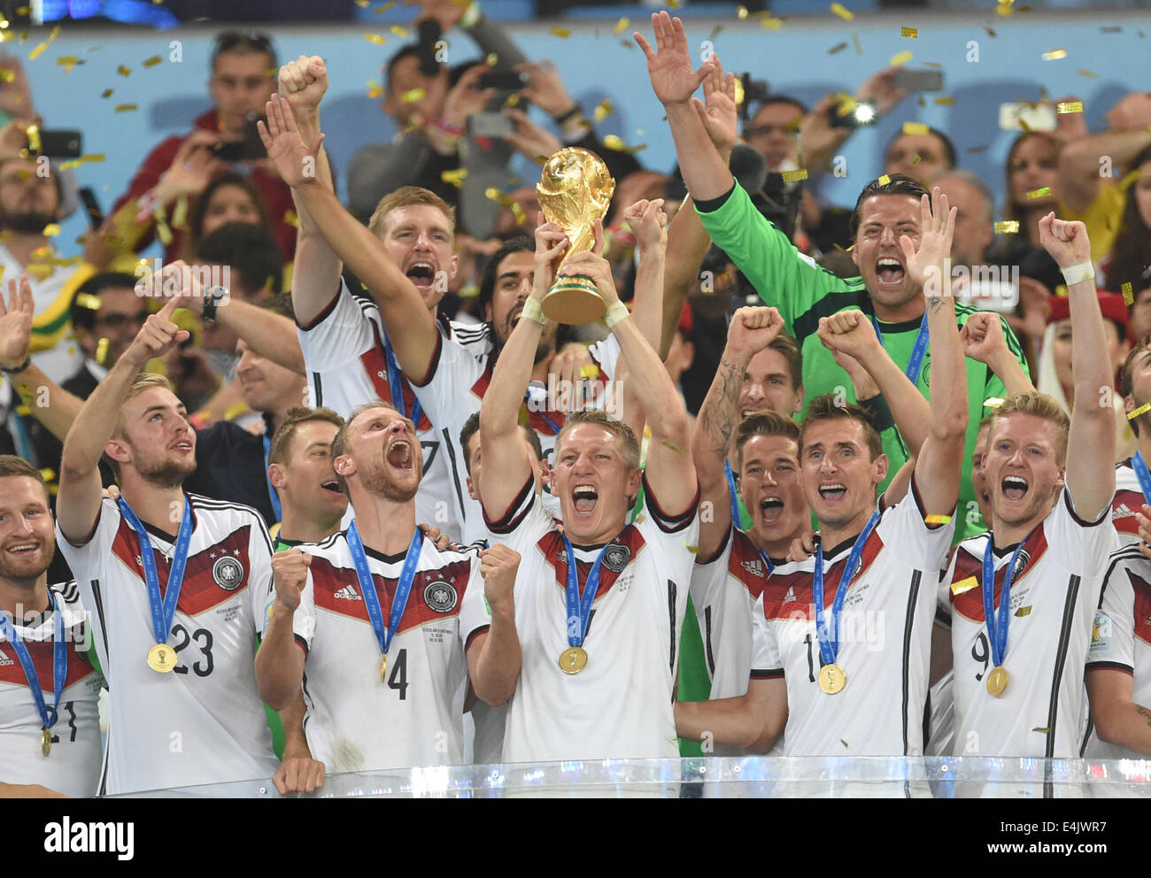 Rio de Janeiro, Brazil. 13th July, 2014. Bastian Schweinsteiger (2C) of Germany lifts up the World Cup trophy after winning the FIFA World Cup 2014 final soccer match between Germany and Argentina at the Estadio do Maracana in Rio de Janeiro, Brazil, 13 July 2014. Photo: Andreas Gebert/dpa/Alamy Live News Stock Photo