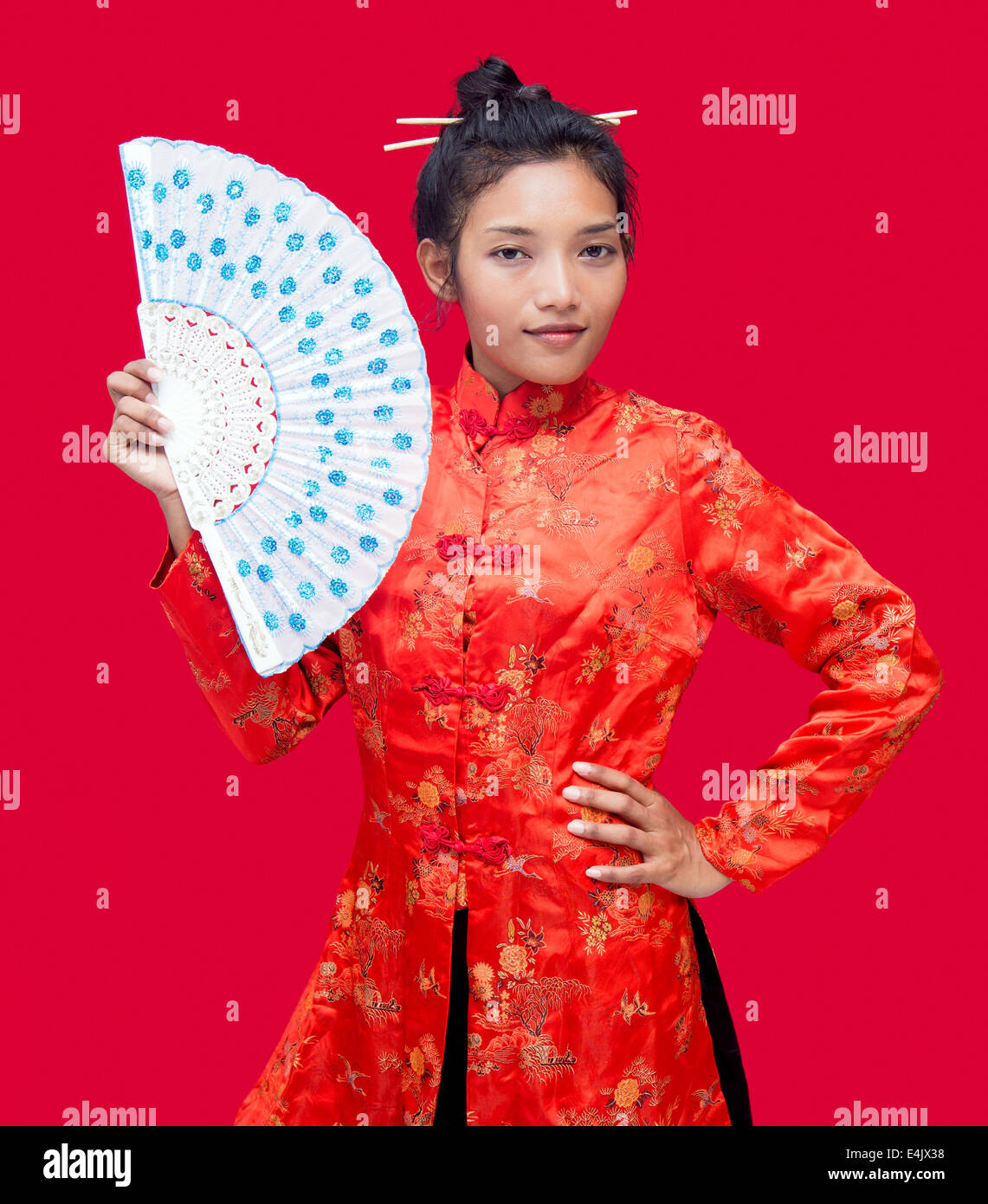 Asian woman with fan on red background Stock Photo