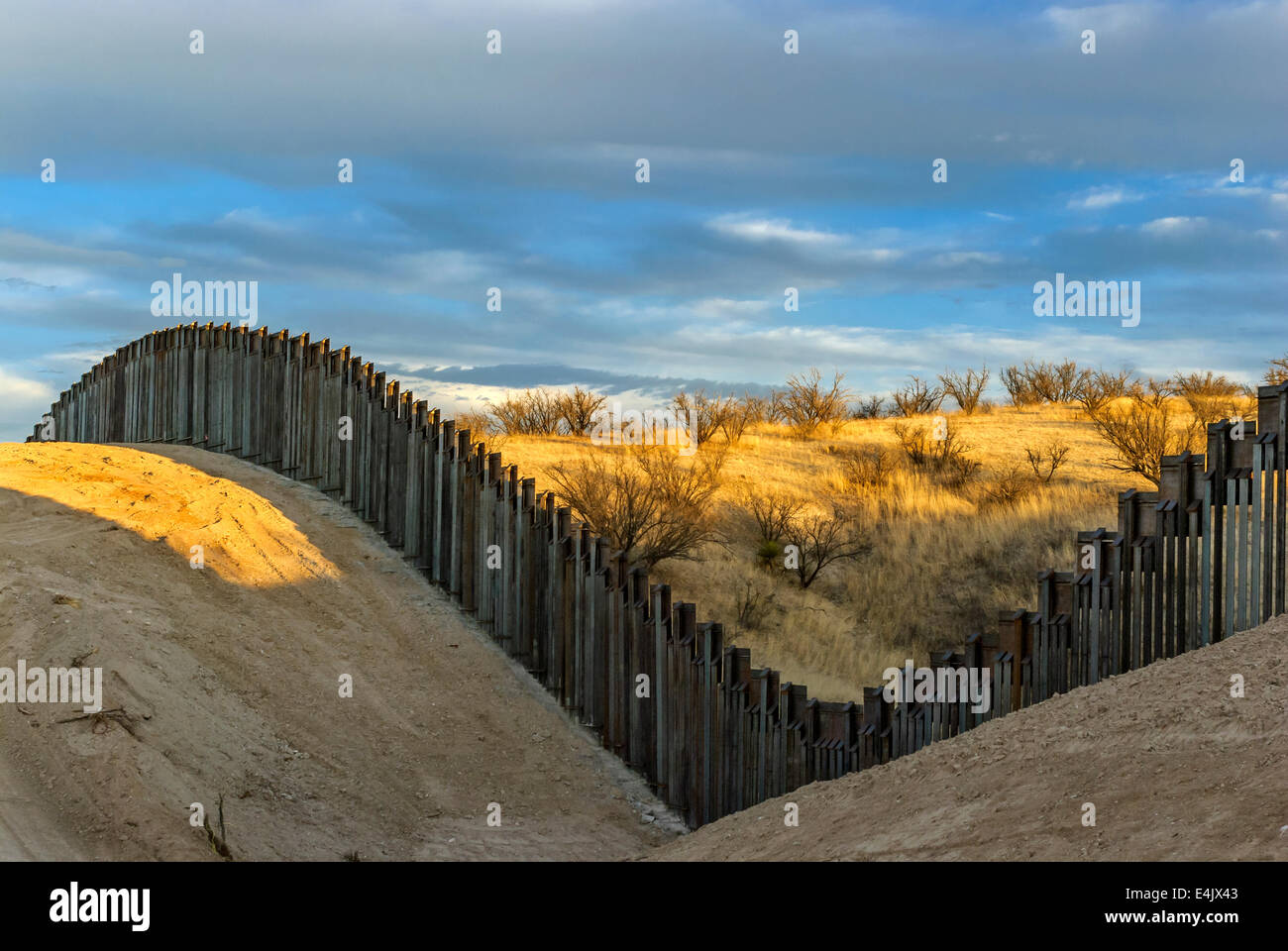 Massive US border fence on border with Mexico, about 6 miles east of Nogales Arizona, USA, viewed from US side at sunset. Stock Photo