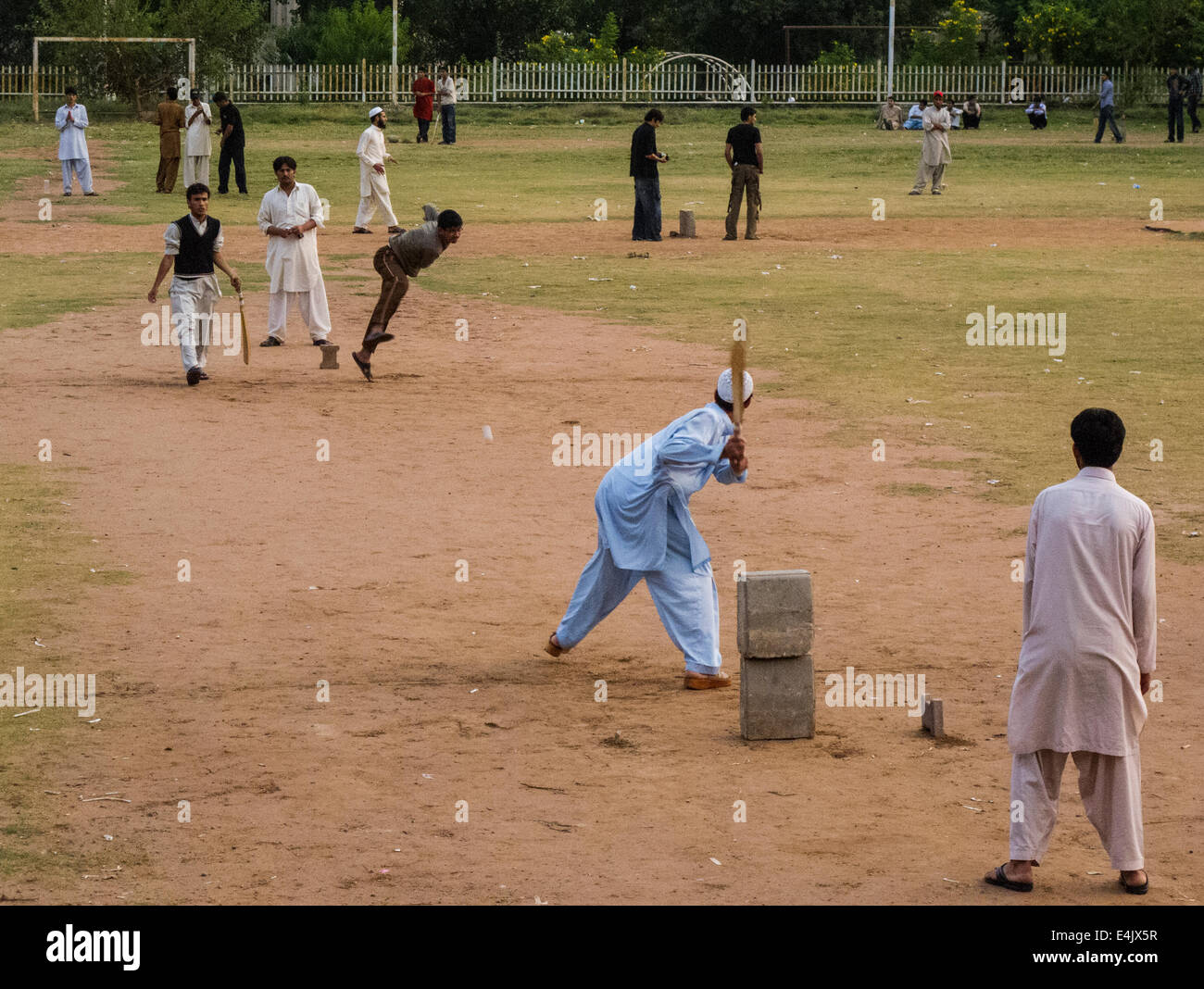 People playing cricket on a park in Islamabad Stock Photo