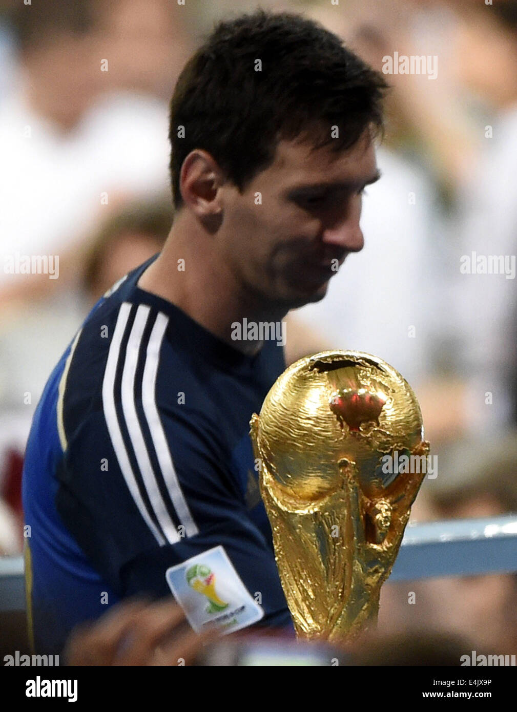 Rio De Janeiro, Brazil. 13th July, 2014. Argentina's Lionel Messi walks by  the World Cup trophy after the final match between Germany and Argentina of  2014 FIFA World Cup at the Estadio