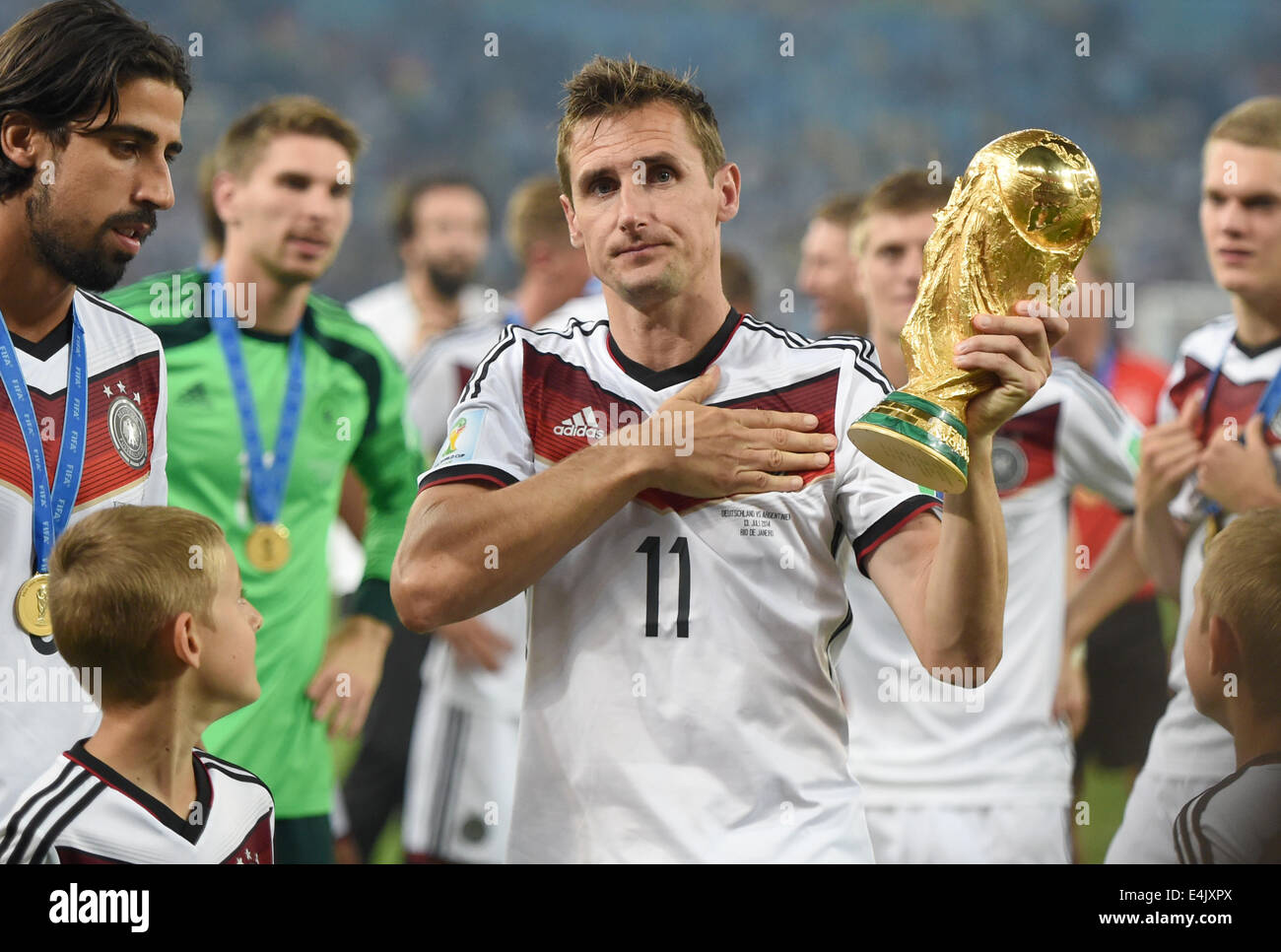 Rio de Janeiro, Brazil. 13th July, 2014. Miroslav Klose of Germany poses with the World Cup trophy and holds the hand on his heart after winning the FIFA World Cup 2014 final soccer match between Germany and Argentina at the Estadio do Maracana in Rio de Janeiro, Brazil, 13 July 2014. Photo: Marcus Brandt/dpa/Alamy Live News Stock Photo
