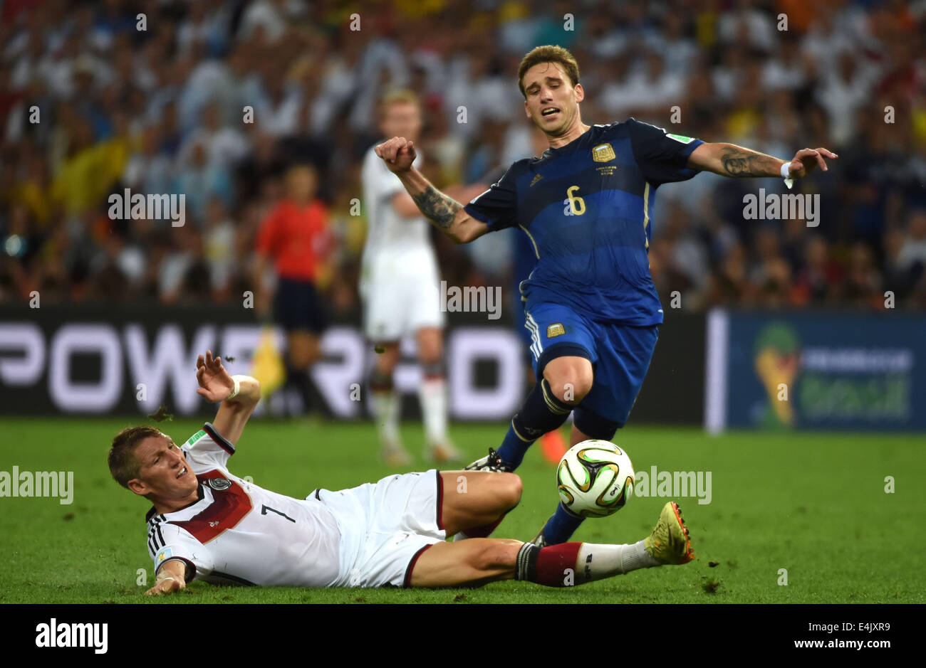 Rio De Janeiro, Brazil. 13th July, 2014. Germany's Bastian Schweinsteiger (L) tackles Argentina's Lucas Biglia during the final match between Germany and Argentina of 2014 FIFA World Cup at the Estadio do Maracana Stadium in Rio de Janeiro, Brazil, on July 13, 2014. Credit:  Guo Yong/Xinhua/Alamy Live News Stock Photo