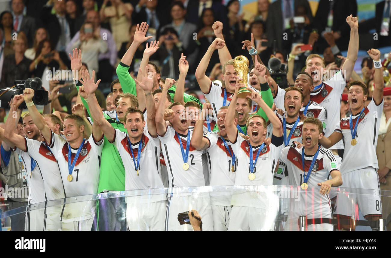 Rio De Janeiro, Brazil. 13th July, 2014. Germany's Philipp Lahm (2nd R, front) holding the FIFA World Cup trophy celebrates with teammates after the final match between Germany and Argentina of 2014 FIFA World Cup at the Estadio do Maracana Stadium in Rio de Janeiro, Brazil, on July 13, 2014. Germany won 1-0 over Argentina after 120 minutes and took its fourth World Cup title on Sunday. Credit:  Liu Dawei/Xinhua/Alamy Live News Stock Photo