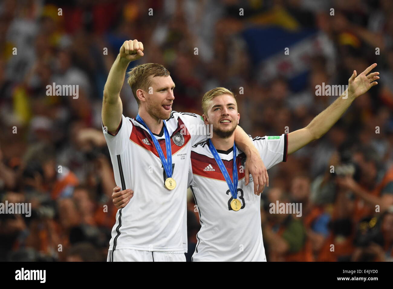 Rio de Janeiro, Brazil. 13th July, 2014. Germany's Per Mertesacker (L) and Christoph Kramer (R) celebrate on the pitch with their gold medals after winning the FIFA World Cup 2014 final soccer match between Germany and Argentina at the Estadio do Maracana in Rio de Janeiro, Brazil, 13 July 2014. Photo: Marcus Brandt/dpa/Alamy Live News Stock Photo