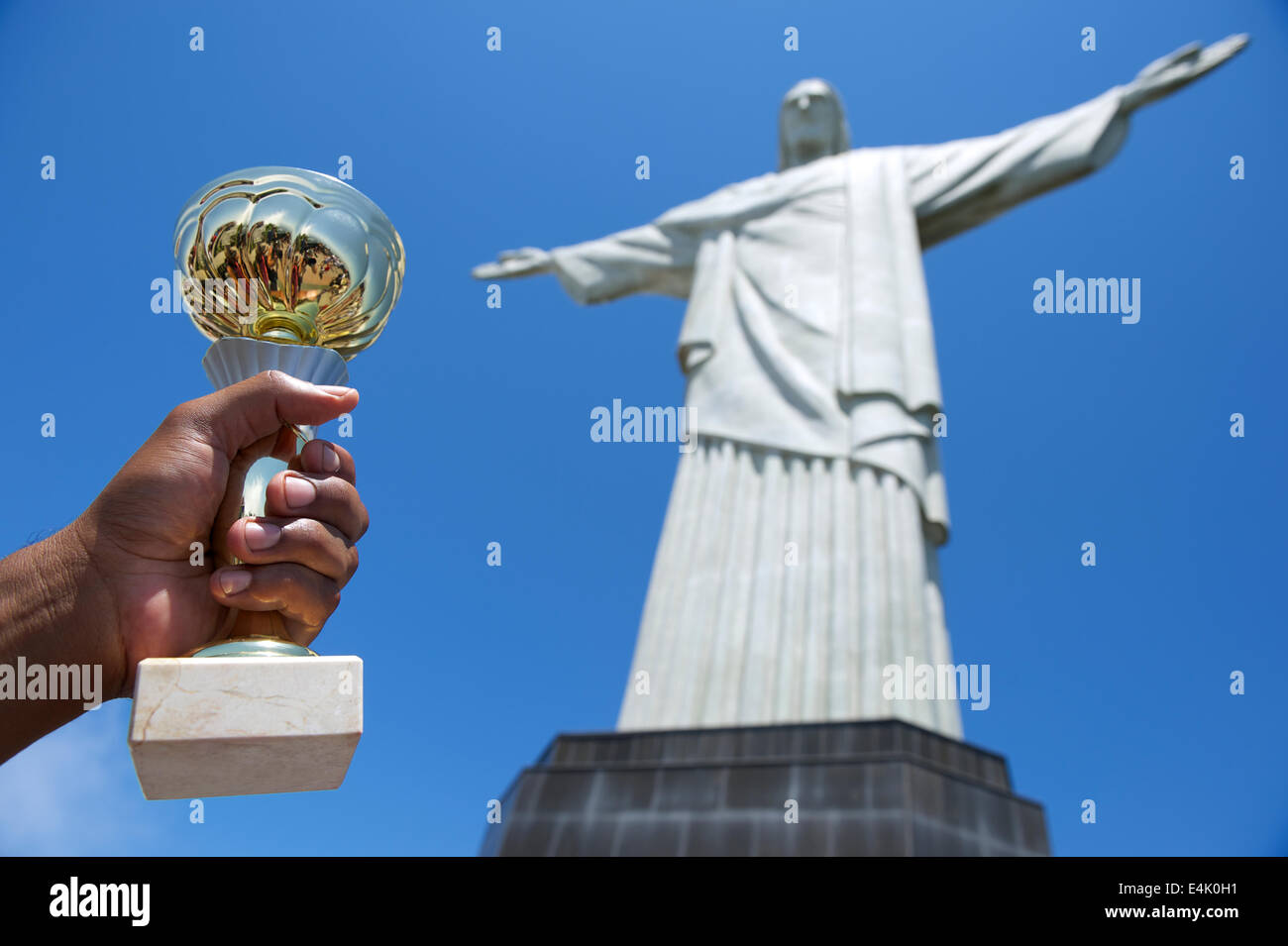 Hand of Brazilian man holding trophy at the statue of Christ the Redeemer at Corcovado Stock Photo