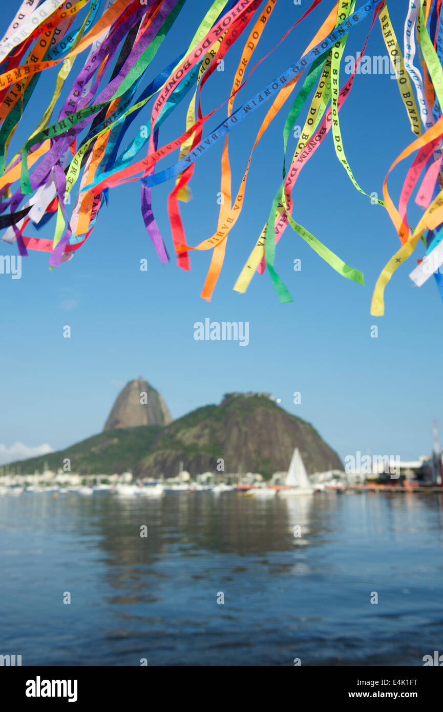 Brazilian wish ribbons flying above scenic view of Sugarloaf Mountain and Botafogo Bay Stock Photo