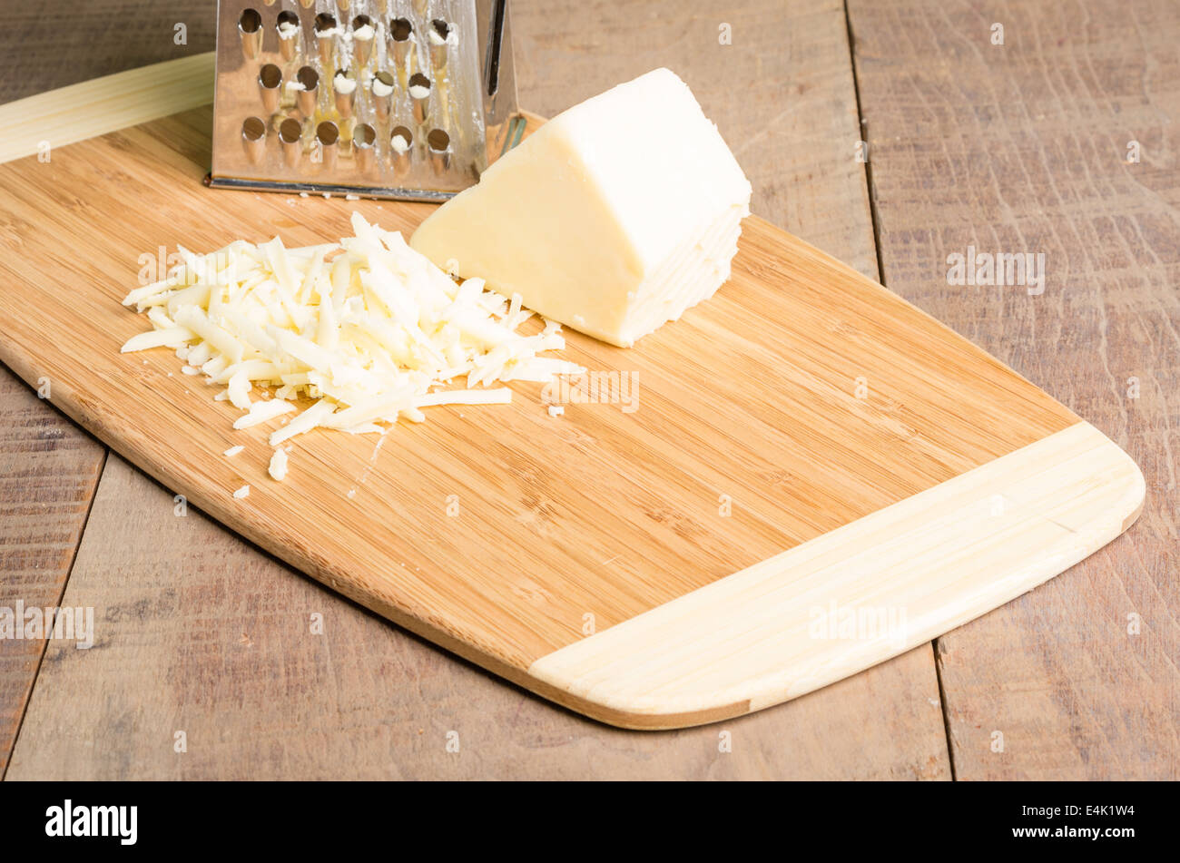 https://c8.alamy.com/comp/E4K1W4/fresh-parmesan-cheese-with-a-metal-grater-on-a-cutting-board-E4K1W4.jpg