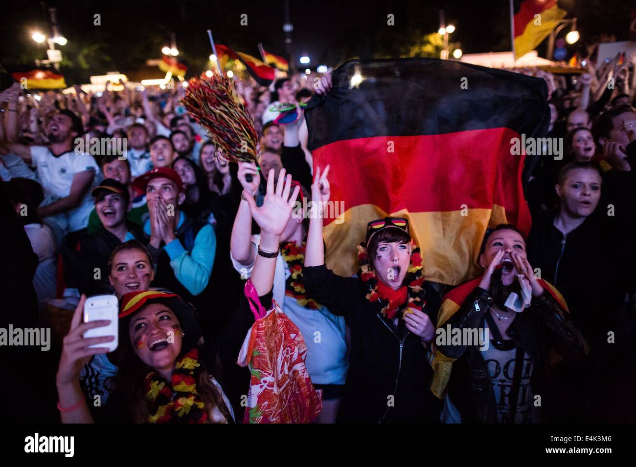 Berlin, Germany. 13th July, 2014. Spectators cheer during the FIFA World Cup 2014 Final match between Germany and Argentina in the fan mile at the Brandenburg Gate in Berlin, Germany, 13 July 2014. Germany won 1-0 and became World Champion. Photo: Maja Hitij/dpa/Alamy Live News Stock Photo