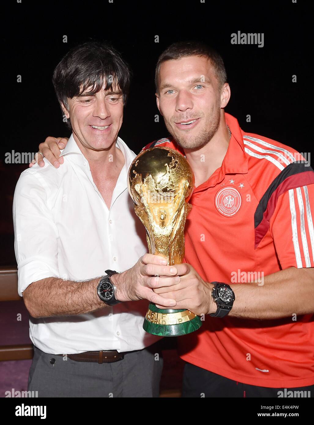 Handout: Rio de Janeiro, Brazil. 14th July, 2014. German coach Joachim Loew (L) and Lukas Podolski celebrating the victory in the Soccer World Cup with the trophy at Hotel Sheraton in Rio De Janeiro, Brazil on 13 July 2014. Germany won 1-0 against Argentina in the FIFA World Cup 2014 Final match. (: Image for in connection with the current reporting on the World Cup and together with the source: Foto: Markus Gilliar/DFB/dpa.) Credit:  dpa picture alliance/Alamy Live News Stock Photo