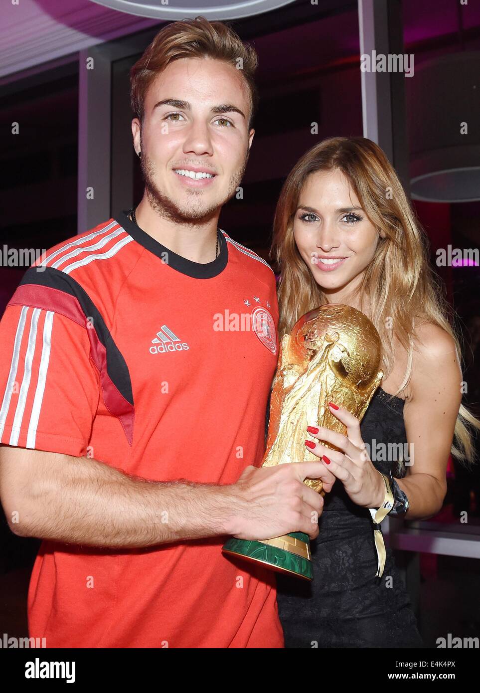 Handout: Rio de Janeiro, Brazil. 14th July, 2014. Mario Goetze (L) and his girlfriend Ann-Kathrin Broemmel celebrating the victory in the Soccer World Cup with the trophy at Hotel Sheraton in Rio De Janeiro, Brazil on 13 July 2014. Germany won 1-0 against Argentina in the FIFA World Cup 2014 Final match. (: Image for in connection with the current reporting on the World Cup and together with the source: Foto: Markus Gilliar/DFB/dpa.) Credit:  dpa picture alliance/Alamy Live News Stock Photo
