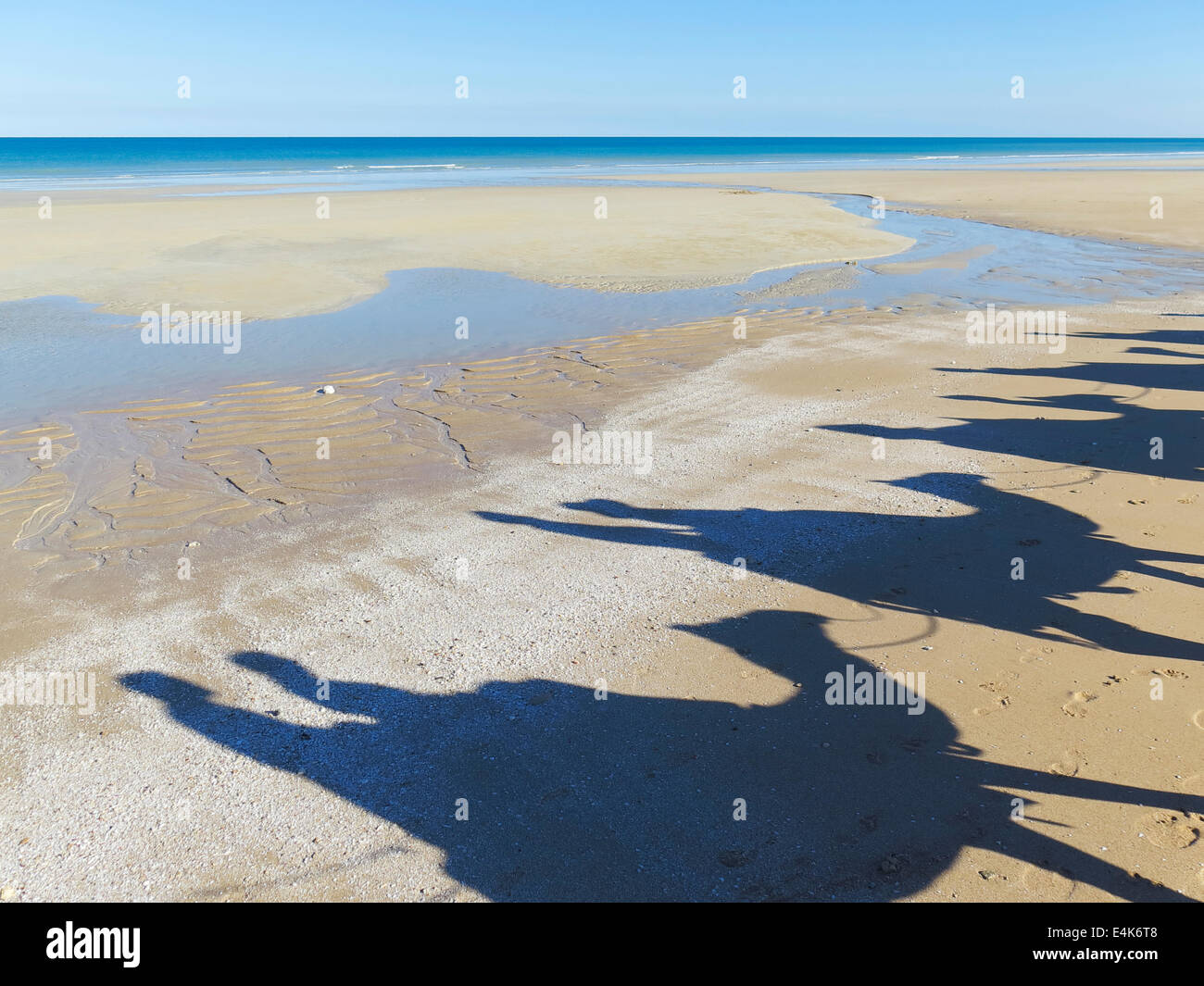 Shadows of a camel train on Cable Beach in Broome, Western Australia Stock Photo