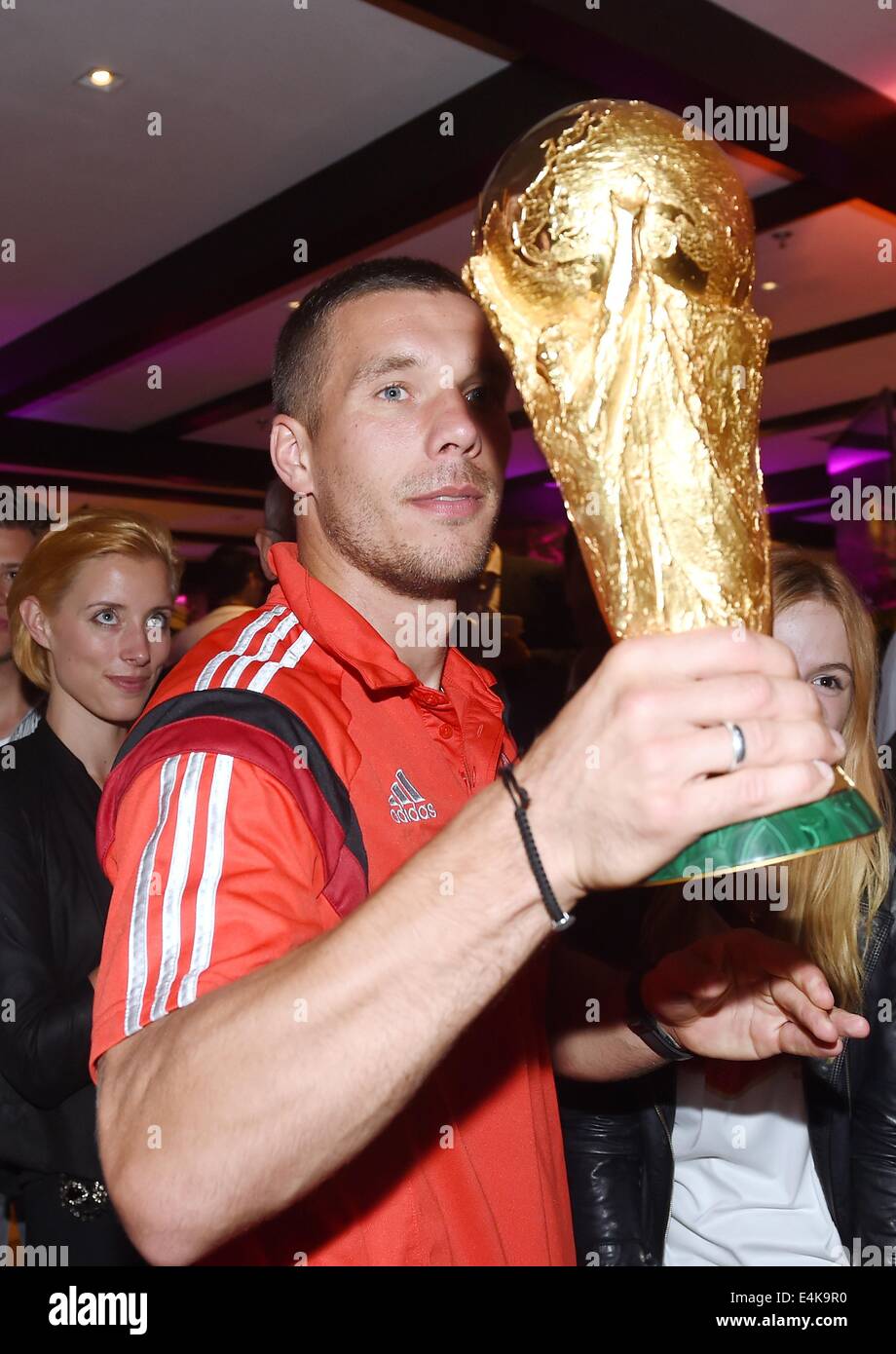 Handout: Rio de Janeiro, Brazil. 14th July, 2014. Lukas Podolski celebrating Germany's victory over Argentina in the Soccer World Cup with the trophy at Hotel Sheraton in Rio De Janeiro, Brazil on 13 July 2014. Germany won the World Cup 1-0 after defeating Argentina. (: Image for in connection with the current reporting on the World Cup and together with the source: Photo: Markus Gilliar/DFB/dpa.) Credit:  dpa picture alliance/Alamy Live News Stock Photo