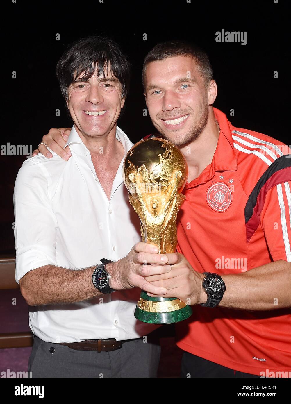Handout: Rio de Janeiro, Brazil. 14th July, 2014. German national coach Joachim Loew (L) and Lukas Podolski celebrating Germany's victory over Argentina in the Soccer World Cup with the trophy at Hotel Sheraton in Rio De Janeiro, Brazil on 13 July 2014. Germany won the World Cup 1-0 after defeating Argentina. (: Image for in connection with the current reporting on the World Cup and together with the source: Photo: Markus Gilliar/DFB/dpa.) Credit:  dpa picture alliance/Alamy Live News Stock Photo