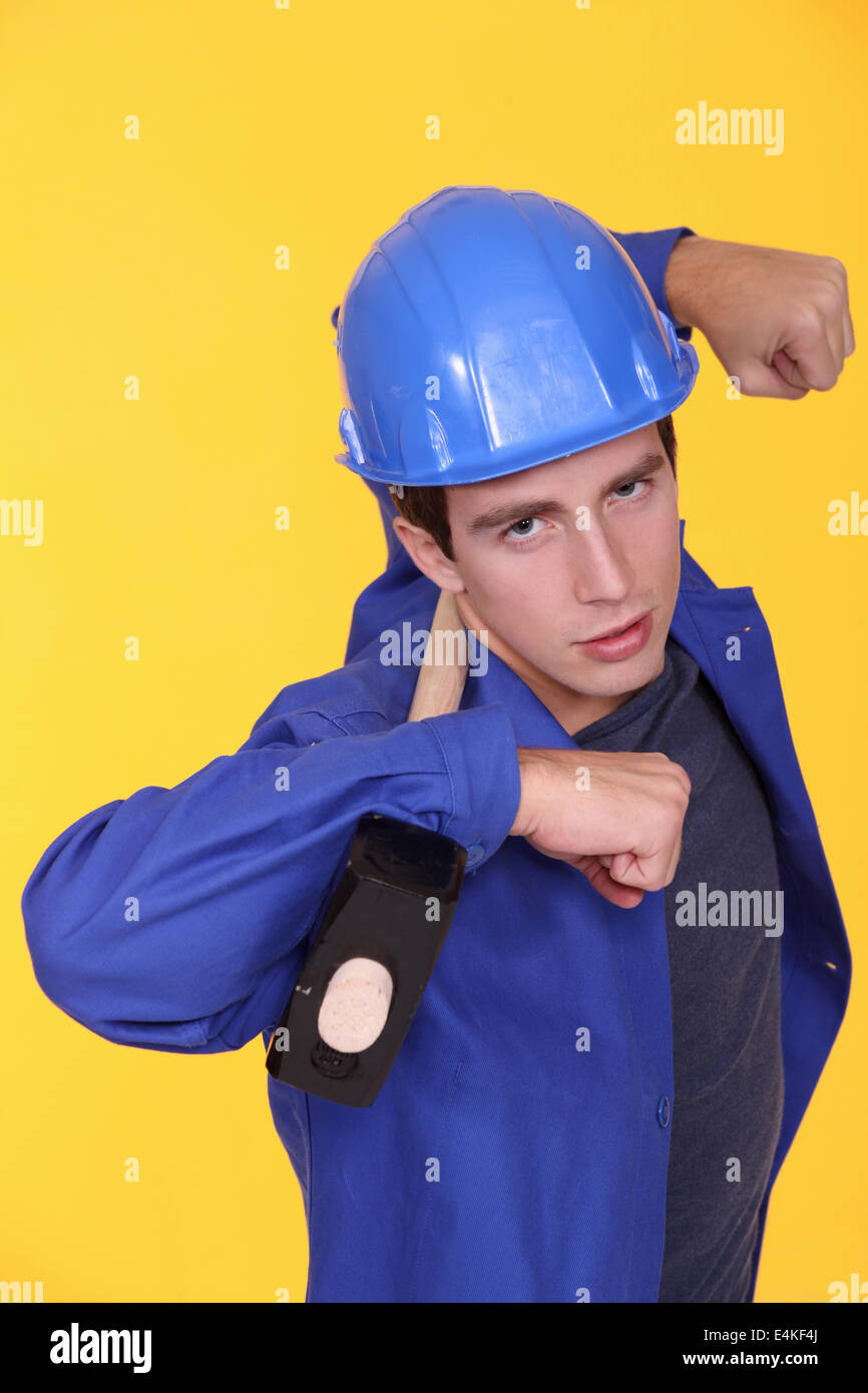 Tradesman holding a mallet on his shoulders Stock Photo