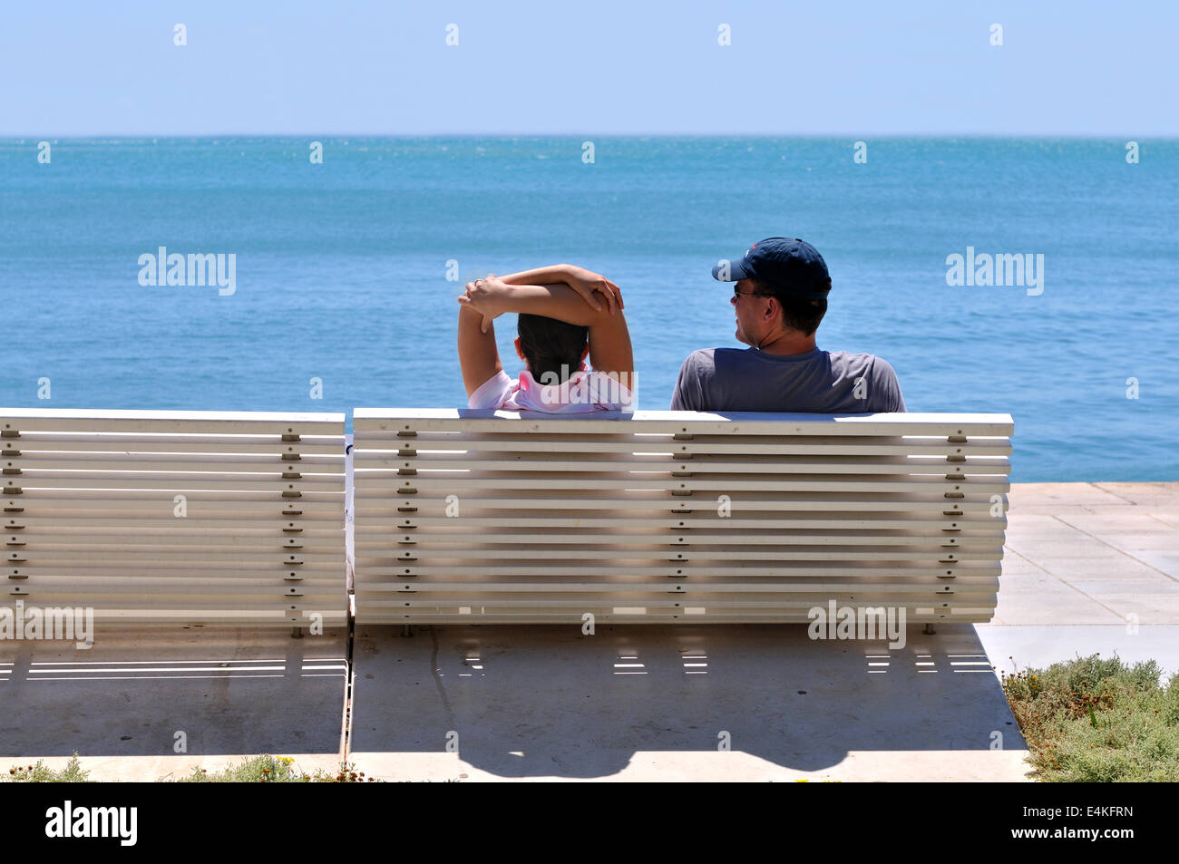 Happy young couple sitting on the beach Stock Photo - Alamy