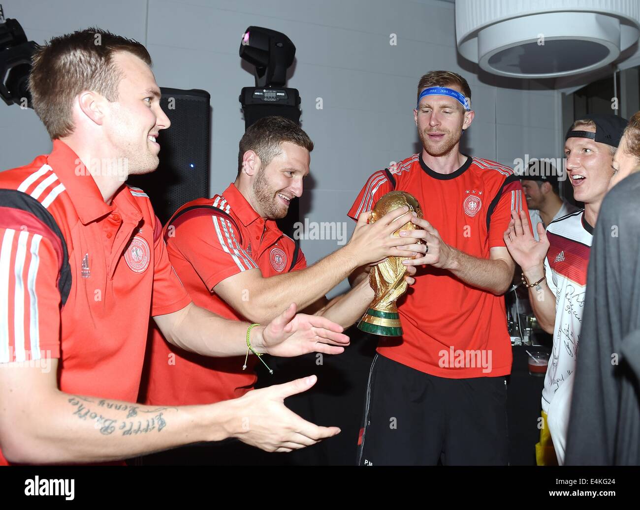 Handout: Rio de Janeiro, Brazil. 14th July, 2014. German Kevin Grosskreutz (L-R), Shkodran Mustafi, Per Mertesacker and Bastian Schweinsteiger Germany's victory over Argentina in the Soccer World Cup with the trophy at Hotel Sheraton in Rio De Janeiro, Brazil on 13 July 2014. Germany won the World Cup 1-0 after defeating Argentina. (: Image for in connection with the current reporting on the World Cup and together with the source: Photo: Markus Gilliar/DFB/dpa.) Credit:  dpa picture alliance/Alamy Live News Stock Photo