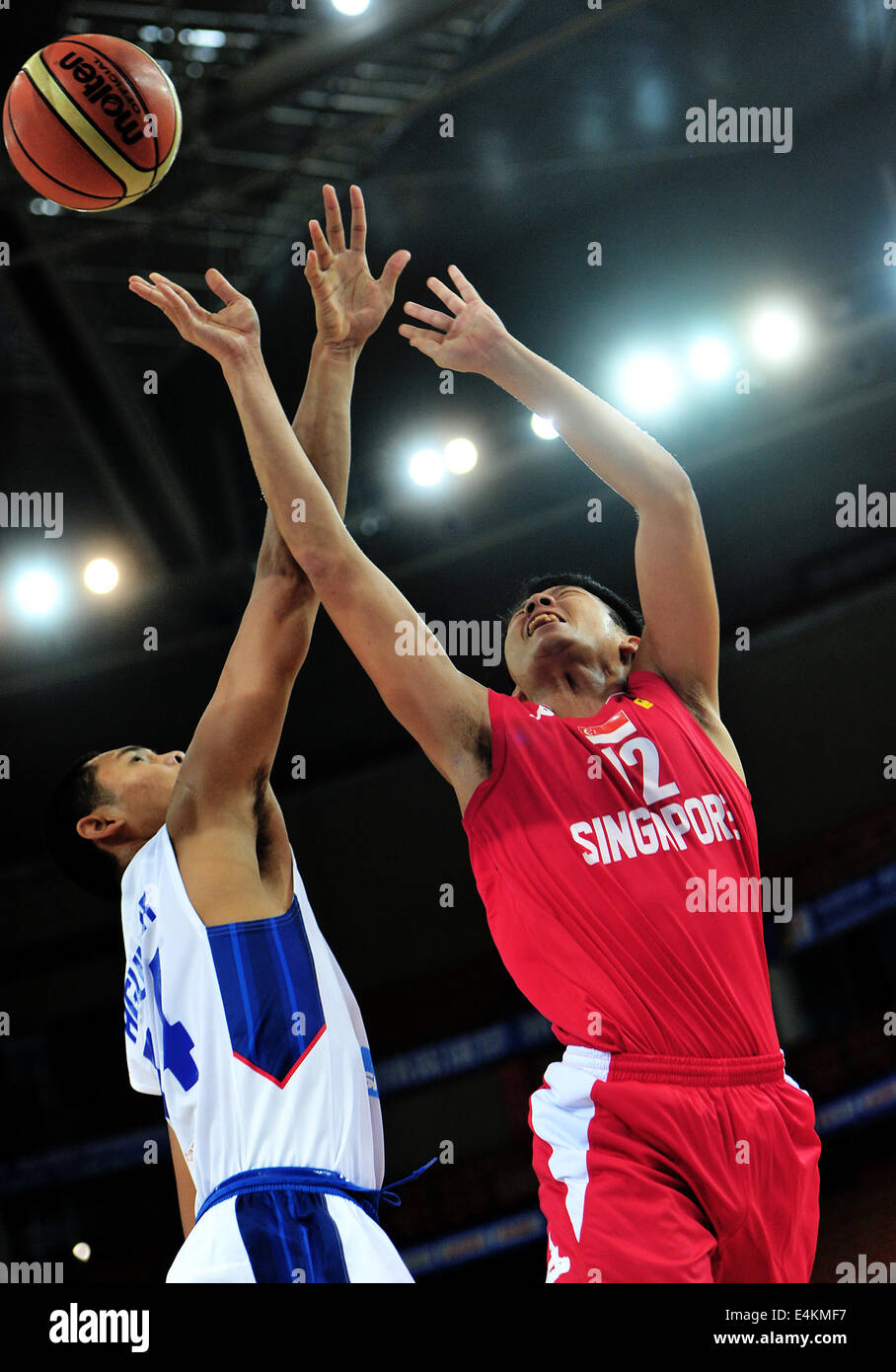 (140714) -- WUHAN, July 14, 2014 (Xinhua) -- Japeth Paul Aguilar (L) of Philippines fights for a rebound during the match between Singapore and Philippines in the 5th FIBA Asia Cup basketball tournament in Wuhan, central China's Hubei Province on July 14, 2014. The Philippines beat Singapore 74-57.(Xinhua/Xiao Yijiu) Stock Photo